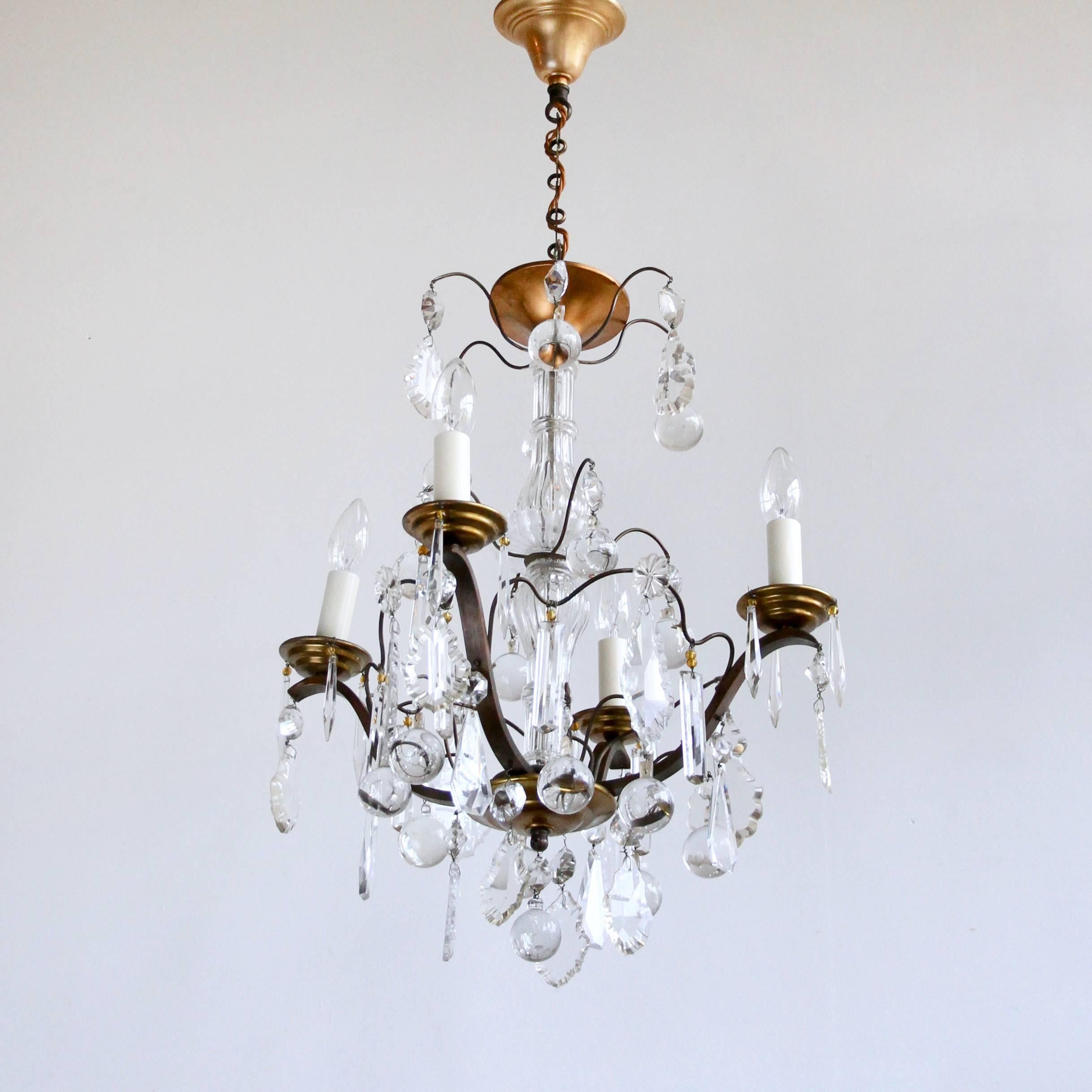 Fully rewired and restored this Louis XIV style chandelier originates from early 1900s France. Retaining its original crystal and glass it is a stunning centre piece. The proportions of the chandelier make it suitable for small space in a period or