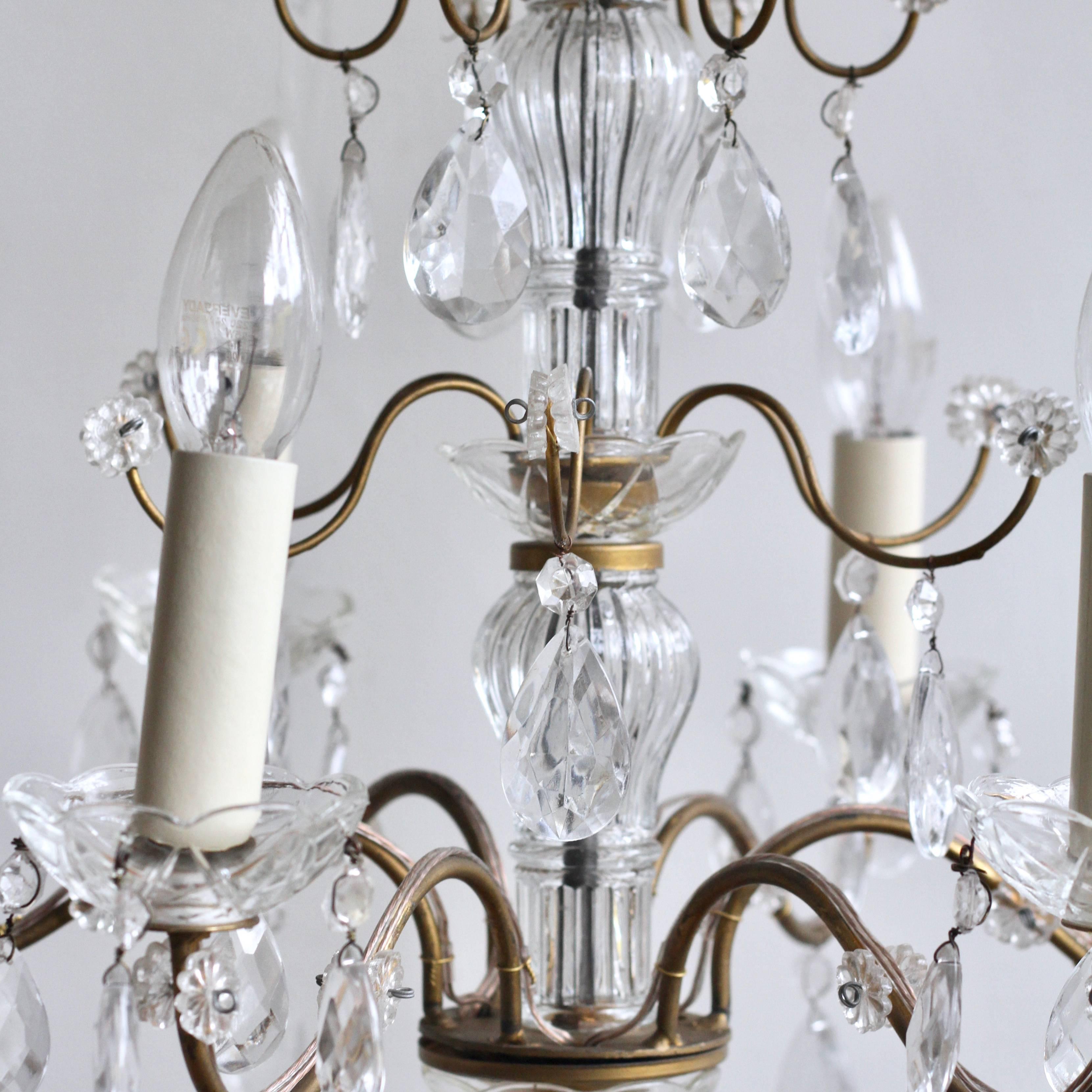 Three delicate pretty French chandeliers available as a set of three. The brass frame retains it's original gold paint which has worn slightly forming a lovely patina. These 1930s French chandeliers are dressed in glass pear drops and glass