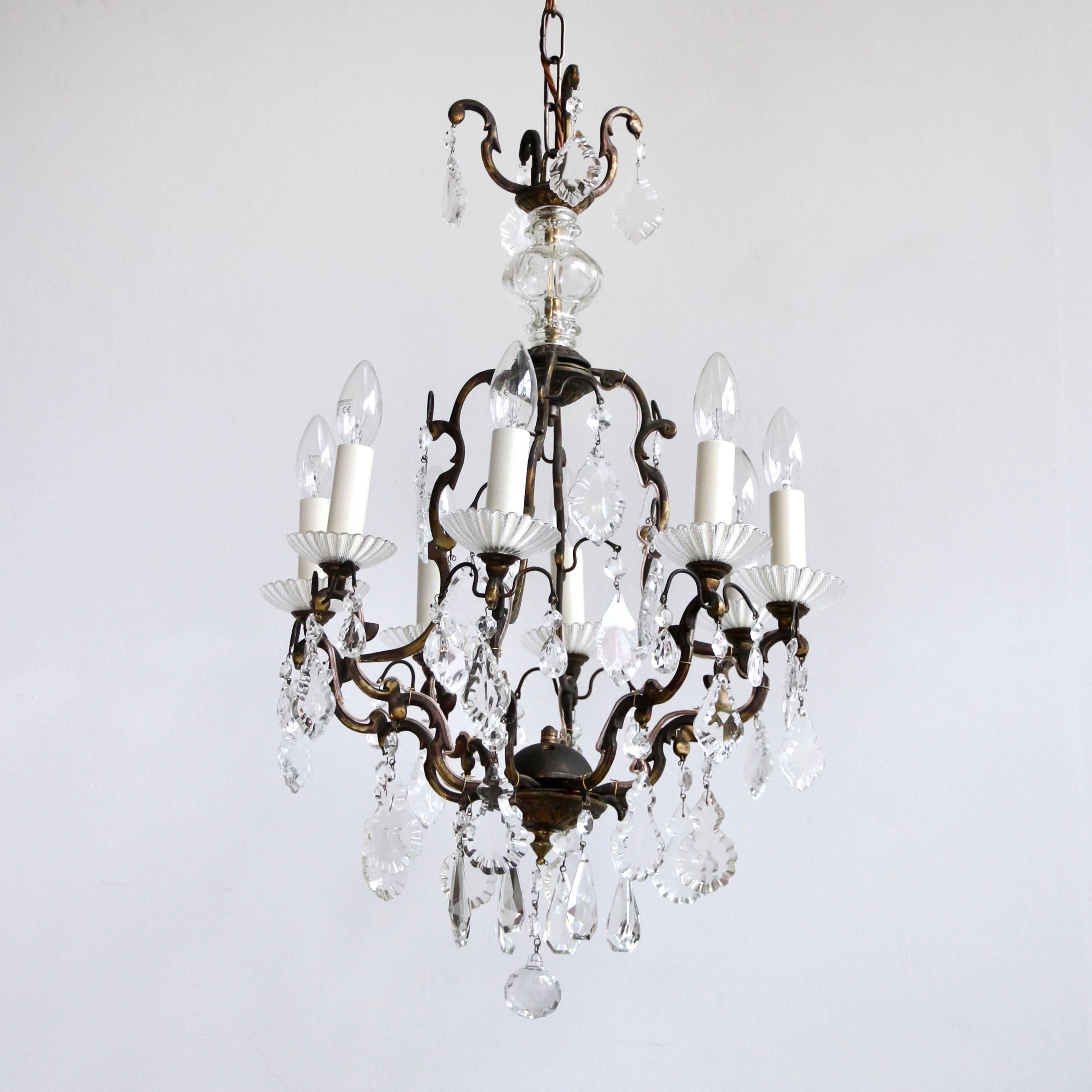 Fully rewired and restored this delicate brass birdcage chandelier originates from early 1900s Italy. Dressed in a mix of hand cut crystal and glass flat leaf drops it is an elegant centre piece. The brass chandelier frame has been partially