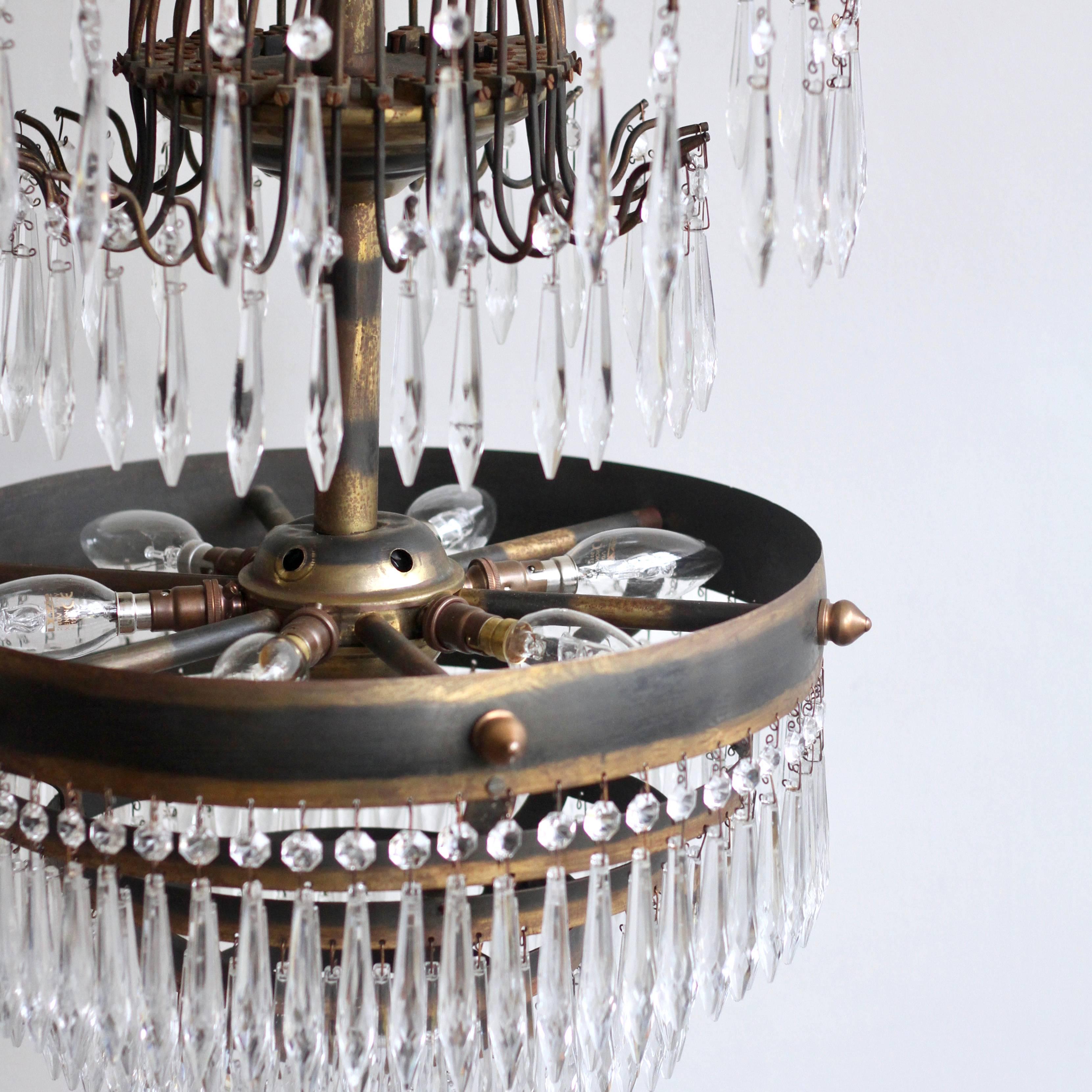 Early 1900s French waterfall chandelier. It has a delicate brass frame with five lower tiers adorned with faceted icicle drops. There are icicles on the top weeping willow-like branches. The chandelier comes supplied with braided flex, chain, a
