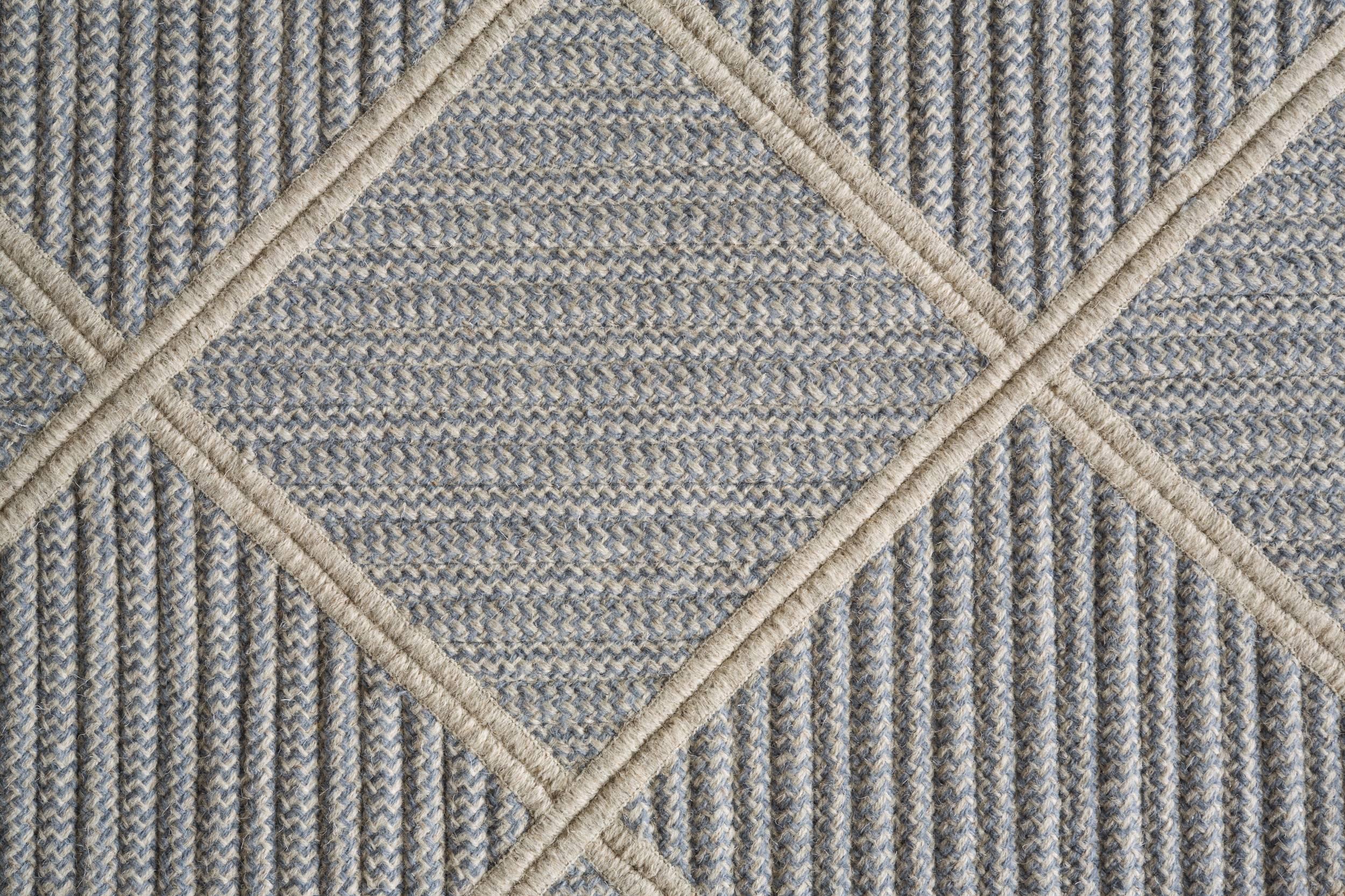 Our Terrain Rug is created by combining blue wool blend with a neutral base of light grey natural un-dyed wool. Alternating styles of cable-woven braid is sewn diagonally, combined and then cut into a circle.  Designed in the Thayer Design Boston