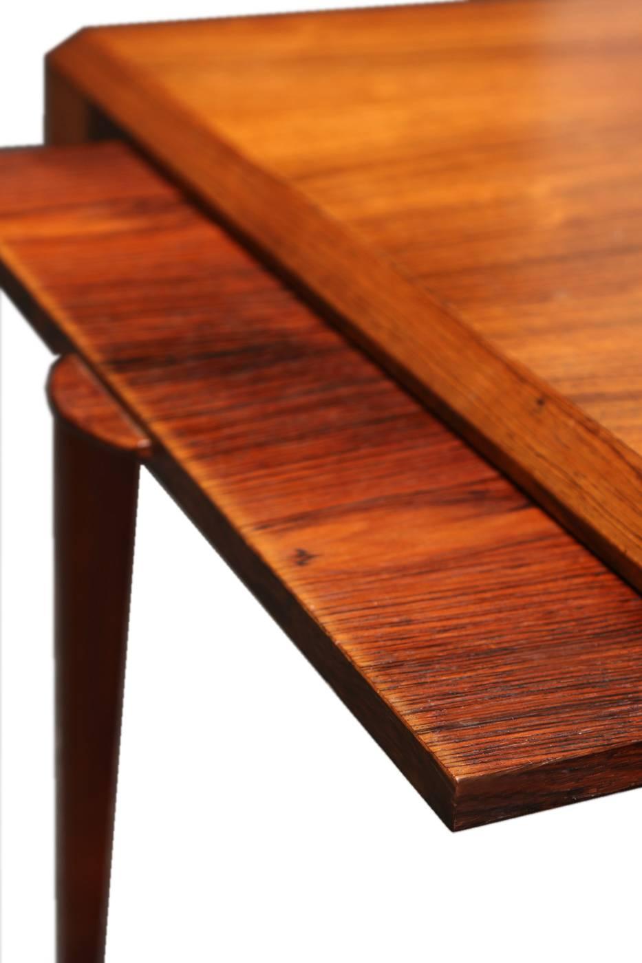A rare coffee table designed by the Danish designer Johannes Andersen during the 1960s, manufactured by CFC Silkeborg in Denmark. It is made from Brazilian rosewood with veneered tops. It features slanted edges and extendable side elements. One of