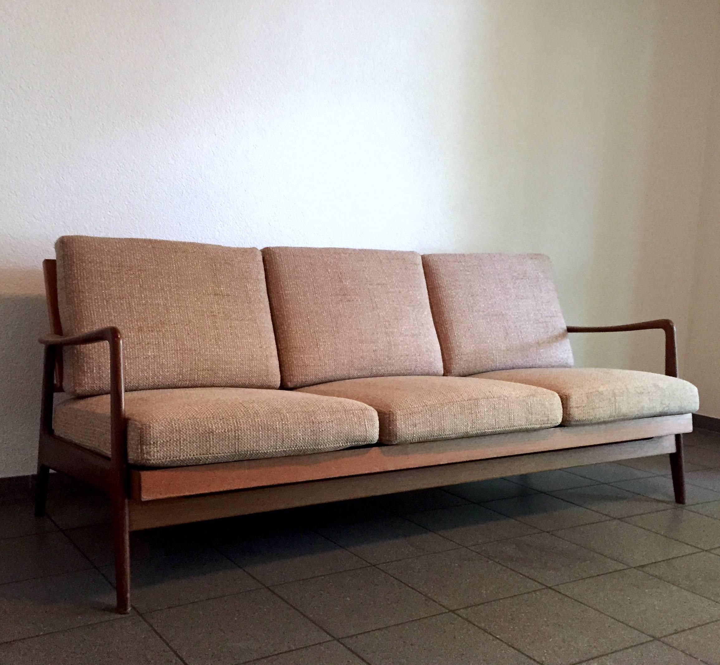 A typical Danish design from the 1960s: this solid teak sofa, can be transformed into a daybed if you slide the mattress a bit forward. It was manufactured in Denmark. The design features a delicate and organically shaped frame with rounded edges.