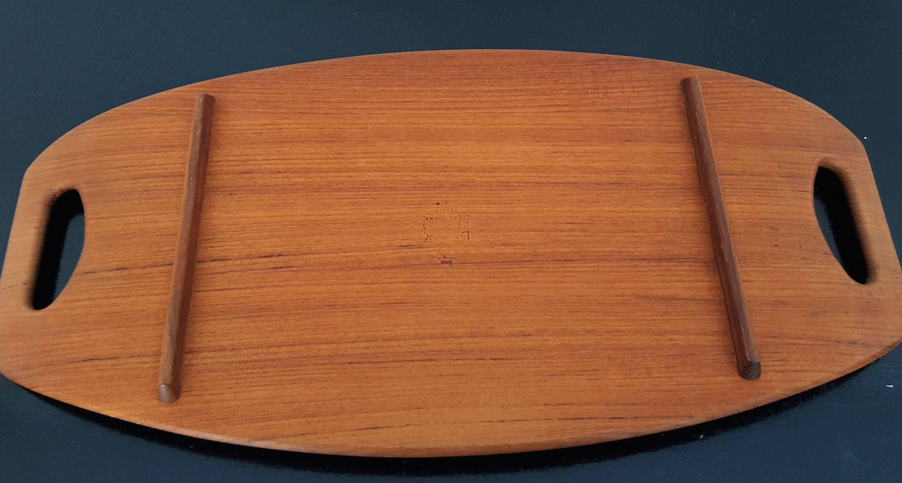 Serving tray designed by Jens Quistgaard in the 1960s and produced by Dansk Design, Denmark. Made from solid teak and stamped to underside. Good vintage condition.
    