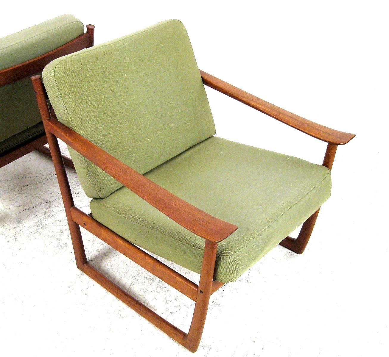 A pair of Mid-Century Danish lounge chairs, model 130, designed by Peter Hvidt & Orla Mølgaard-Nielsen in 1961 and manufactured by France & Søn in Denmark. The frame is made of solid teak, the armrests are slightly shovel-shaped. The loose