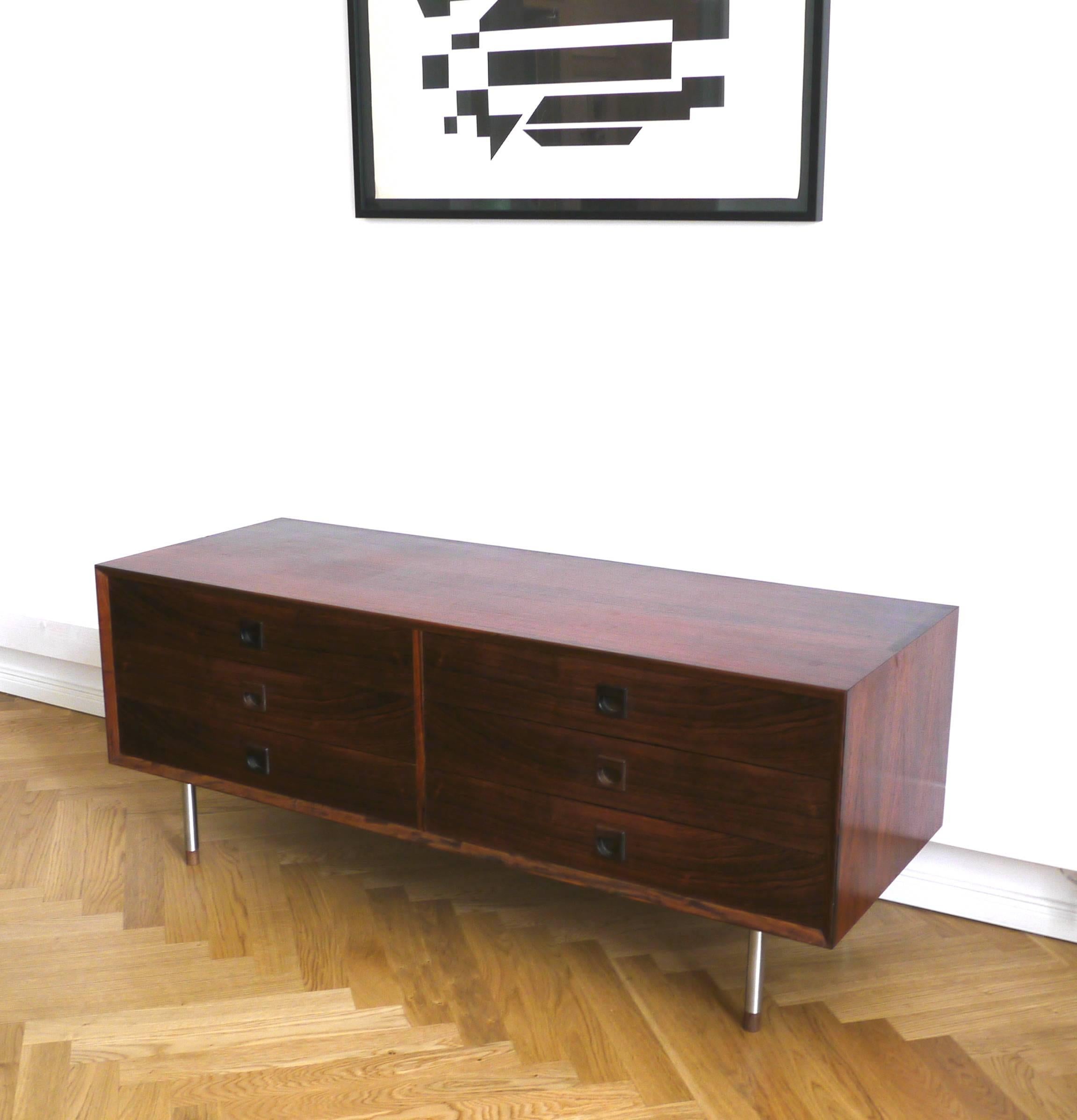 This compact lower sideboard or chest of drawer is made in 1960s in Denmark by Brouer Møbelfabrik. The rosewood veneer shows a remarkable wood grain. The simple and classic corpus features six drawers and organic handles made in rosewood. The