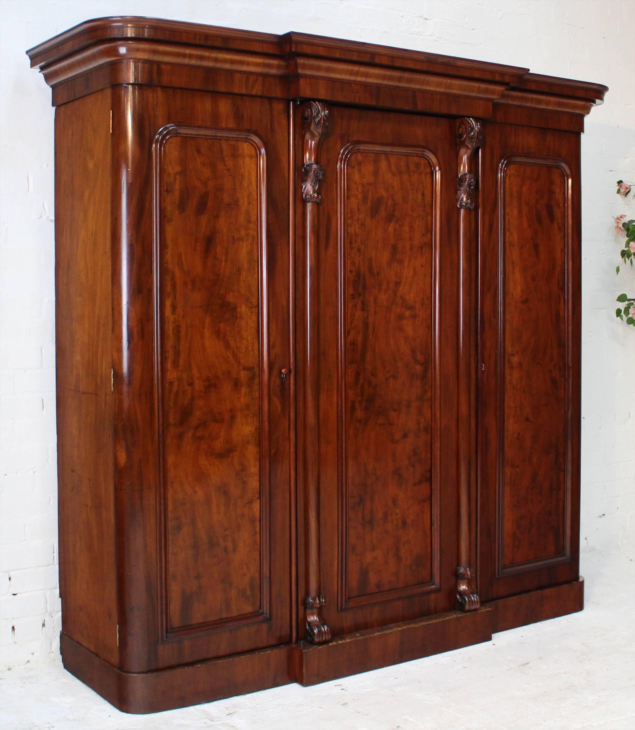 A fabulous Victorian breakfront wardrobe of super quality and dating to circa 1860. Featuring richly colored well figured mahogany and crisply carved floral and acanthus leaf carved corbels and columns flanking the central door.

With a moulded