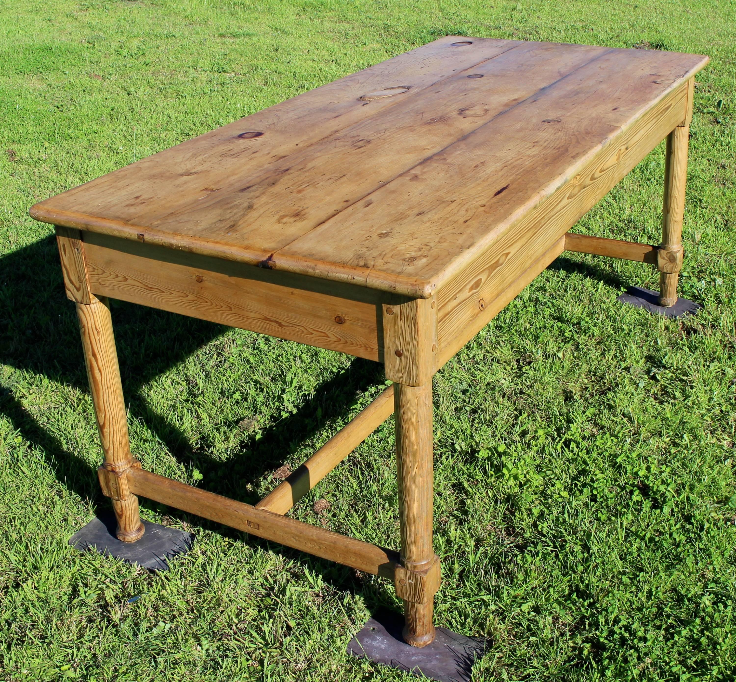 A simple 19th century pine refectory style kitchen or country dining table full of character and charm. The three plank top full of natural marking including knots and tunnels as well as markings of wear over the years. Solidly constructed on a