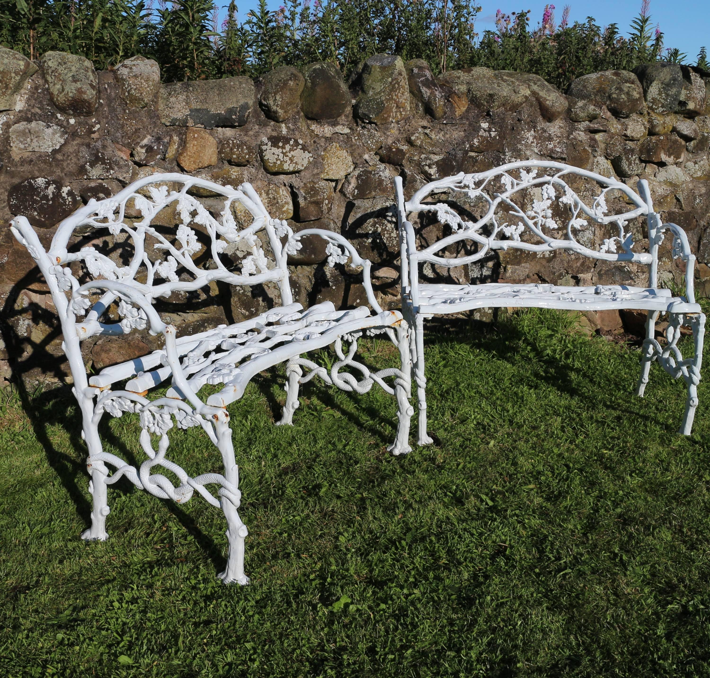 A Victorian pair of cast iron garden seats in the serpent and twig pattern and dating circa 1860. These beautiful rustic naturalistic castings are based on the English oak tree and depict branches adorned with oak leaves, acorns and intertwined