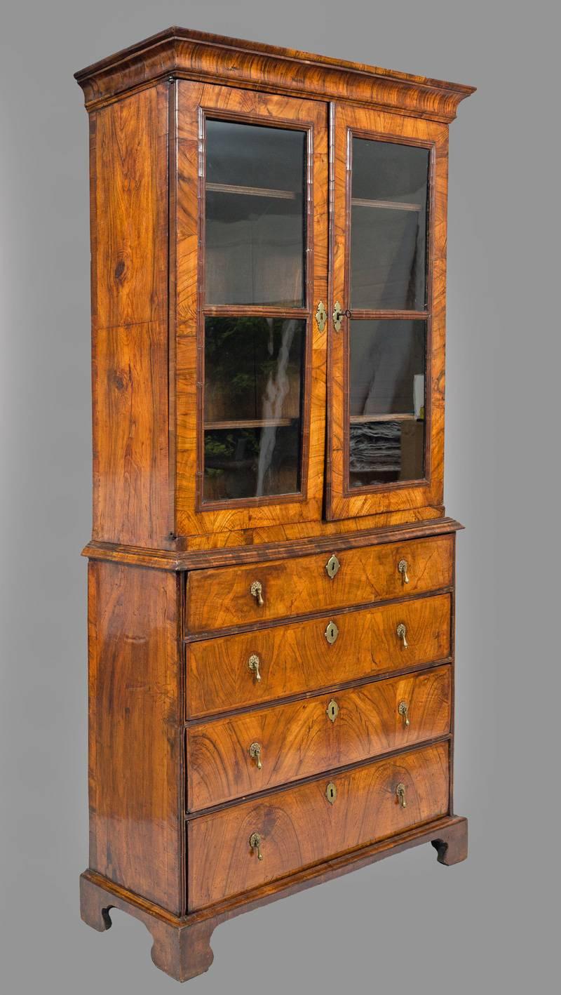 Fine George I walnut Secretaire Bookcase with overhanging cavetto cornice above a pair of glazed doors, enclosing three shelves, above one long drawer with a fall front writing surface and fitted interior with four small drawers and pigeon holes.