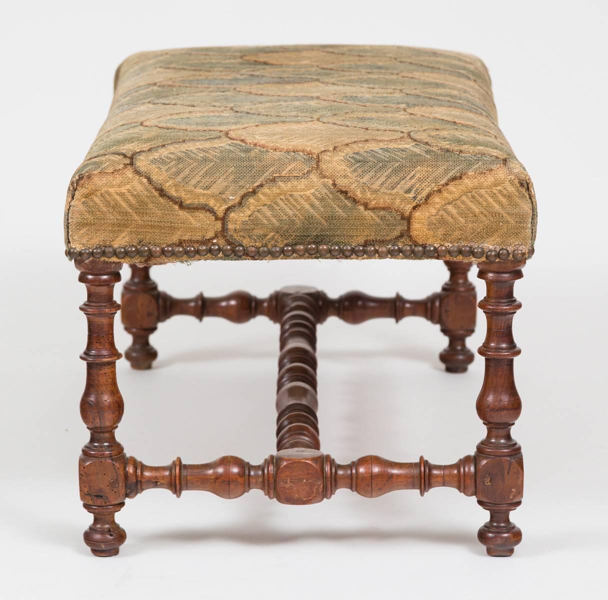 Flemish walnut long stool or bench with rectangular stuff-over seat finished with brass nailheads above four pegged baluster turned legs joined by H-shaped stretchers. Upholstered in old velvet fabric.