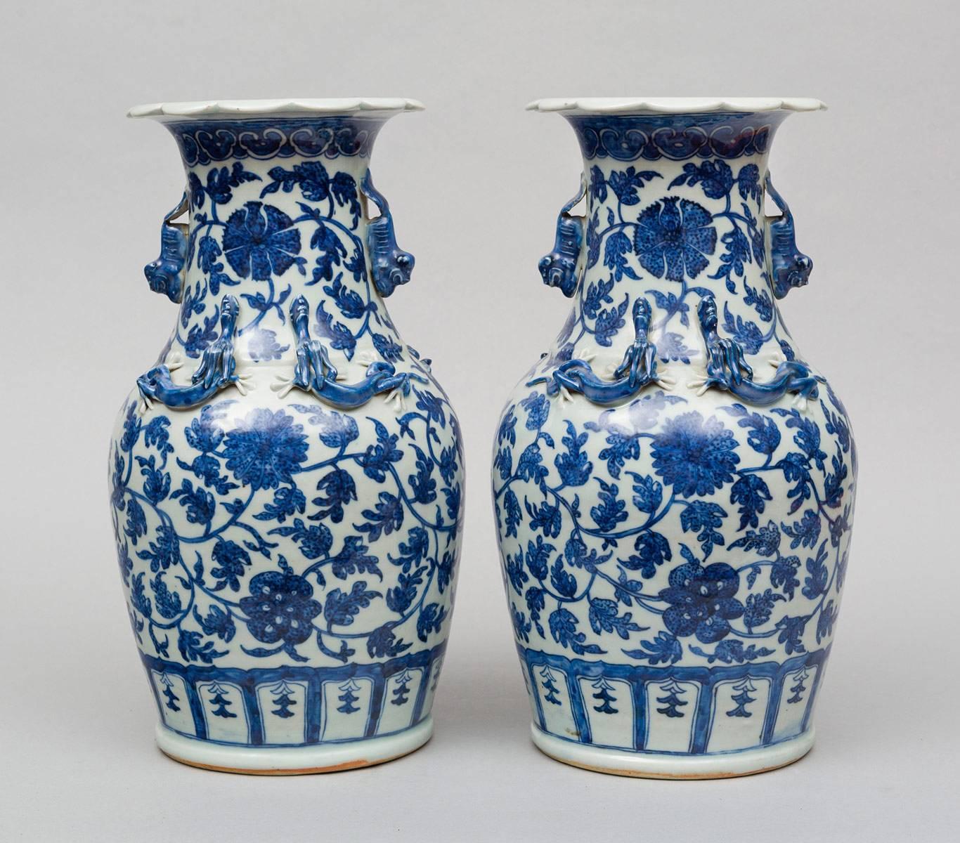 Pair of Chinese blue and white open baluster-shaped vases with turn-over scalloped rims, decorated with applied foo dog handles at the neck and the body with pairs of applied dragons front and back, the whole decorated with meandering scrolls of