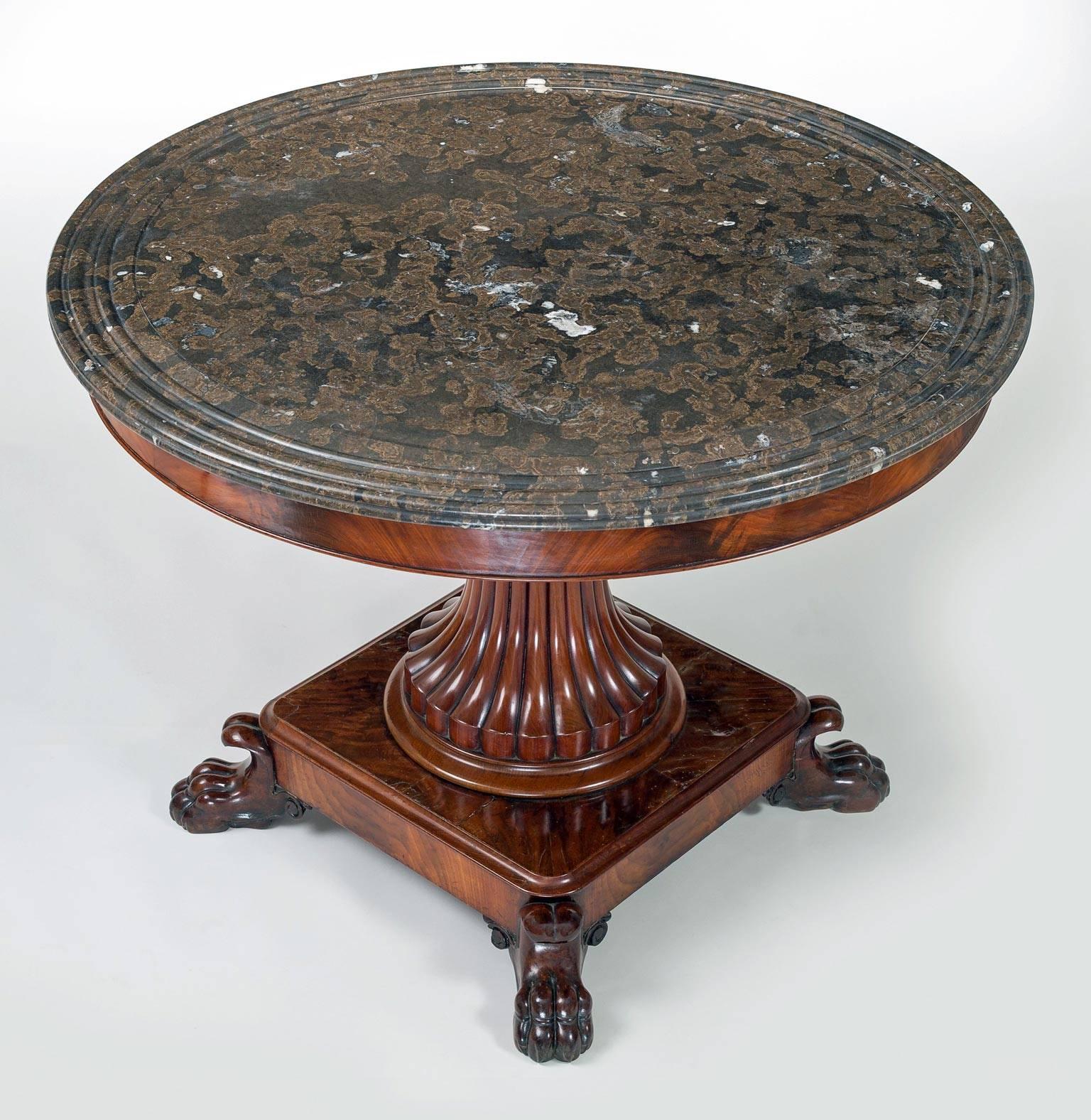 French Charles X mahogany gueridon or center table with original circular molded mottled brown and black marble top above carved splayed reeded pedestal on square molded base with carved C-scroll lion’s paw feet.