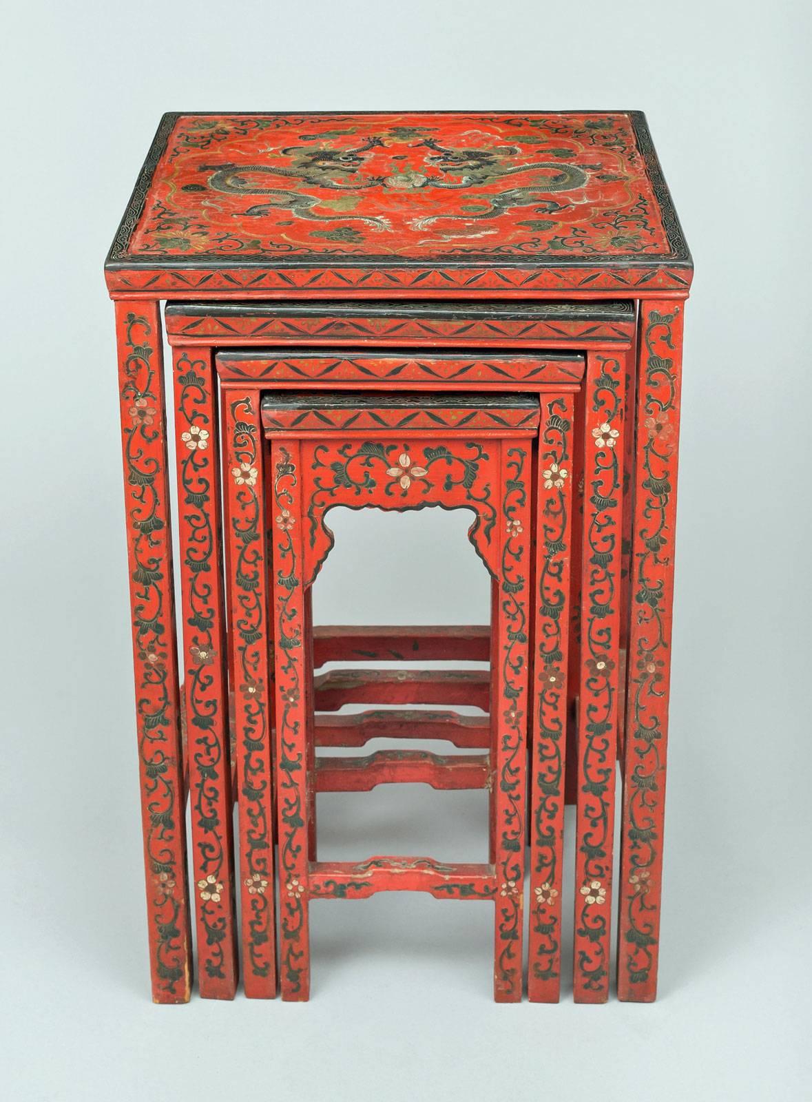 Chinese lacquered nest of four graduated “quarteto” or nesting tables, each top is decorated with fantastical dragons on red background  above shaped aprons.  All decorated with swags and garlands of foliage and flowers.

    

   
