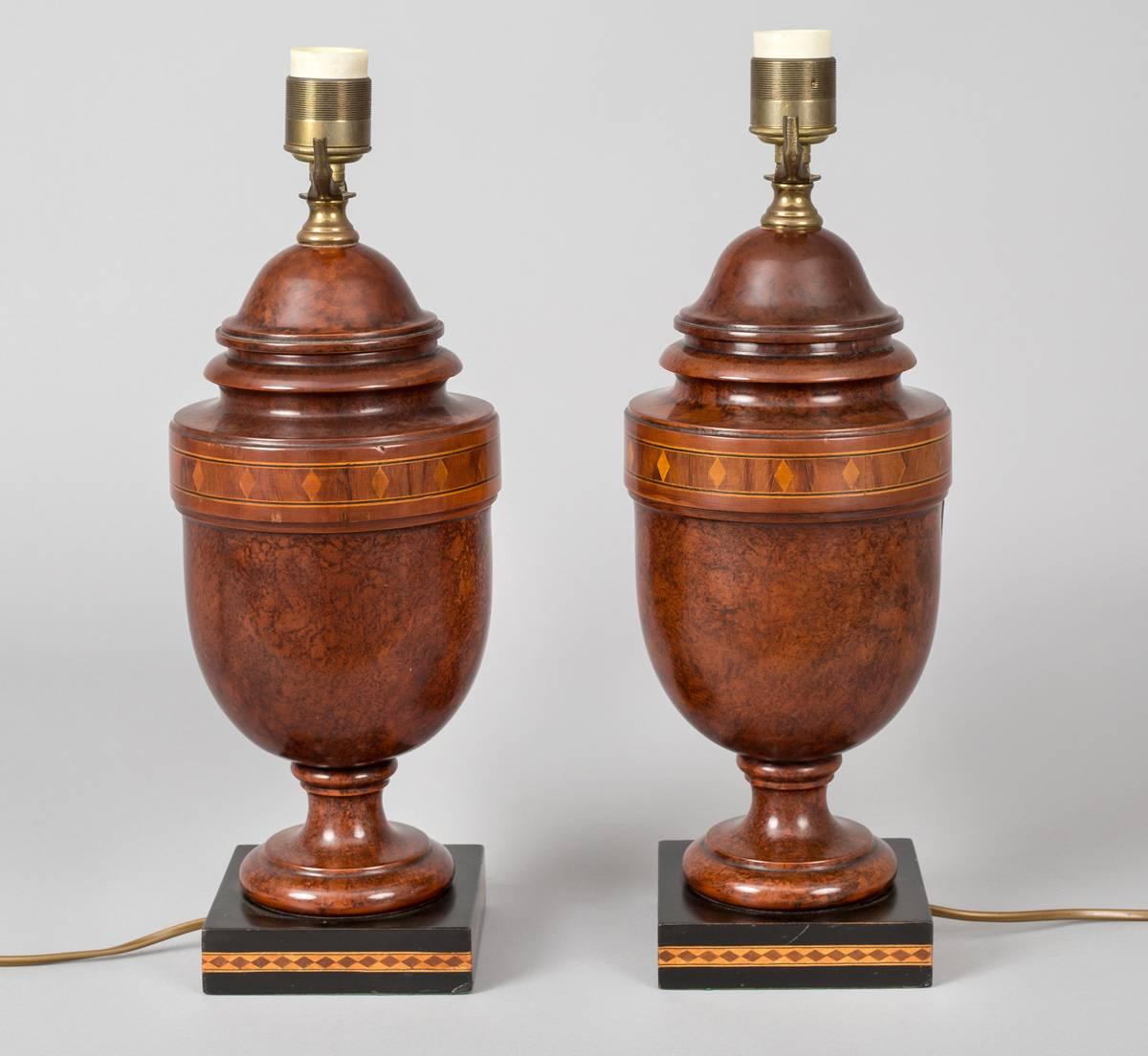 Pair of burl walnut inlaid vase-shaped lamps decorated with diamond patterned inlay around the top and base, mounted on an ebonized square base.