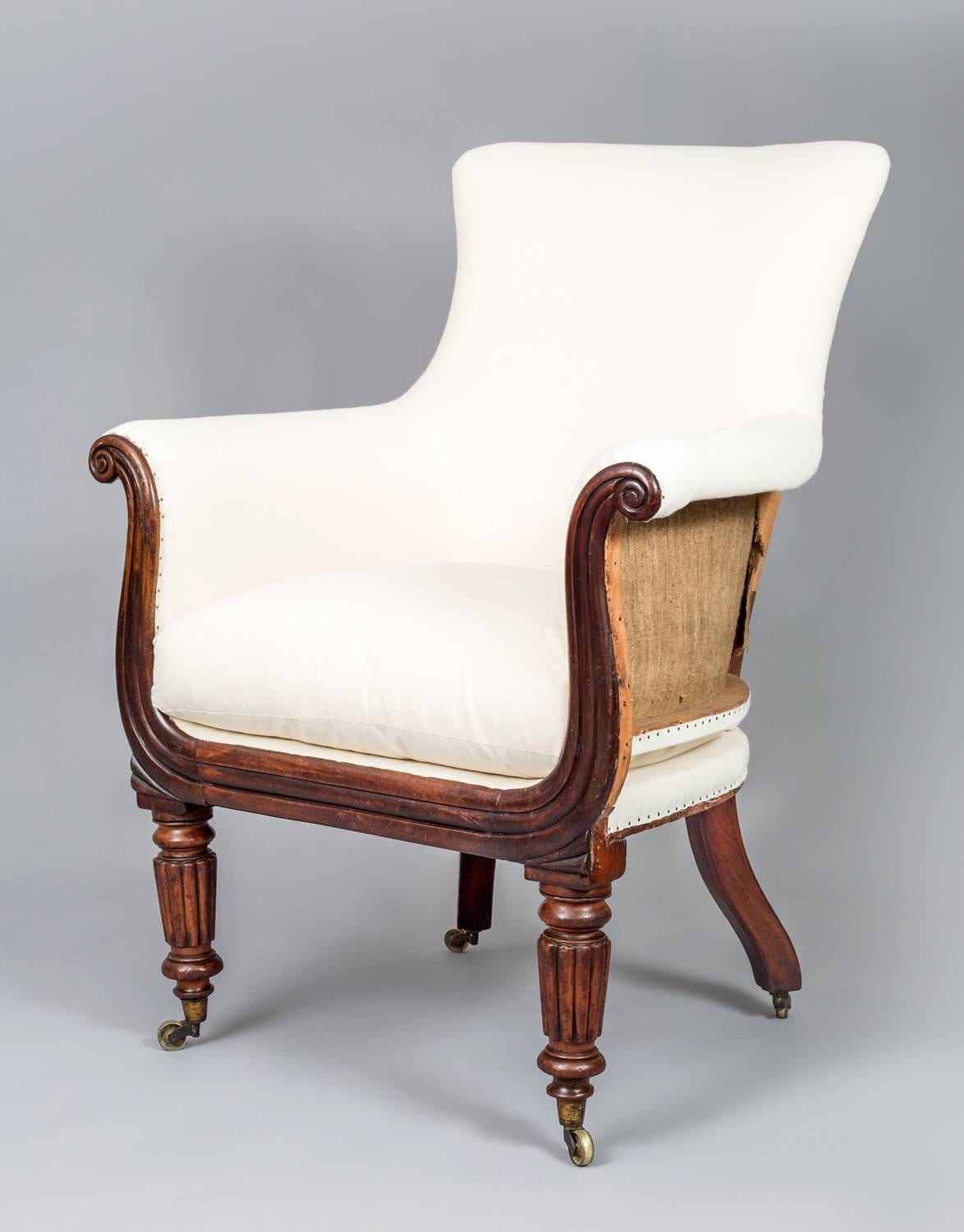 Regency mahogany lyre-shaped armchair, the down filled cushion seat on reeded turned tapering front legs, back swept back legs, all on brass casters. Partially upholstered in white cotton. Ready for re-upholstery.