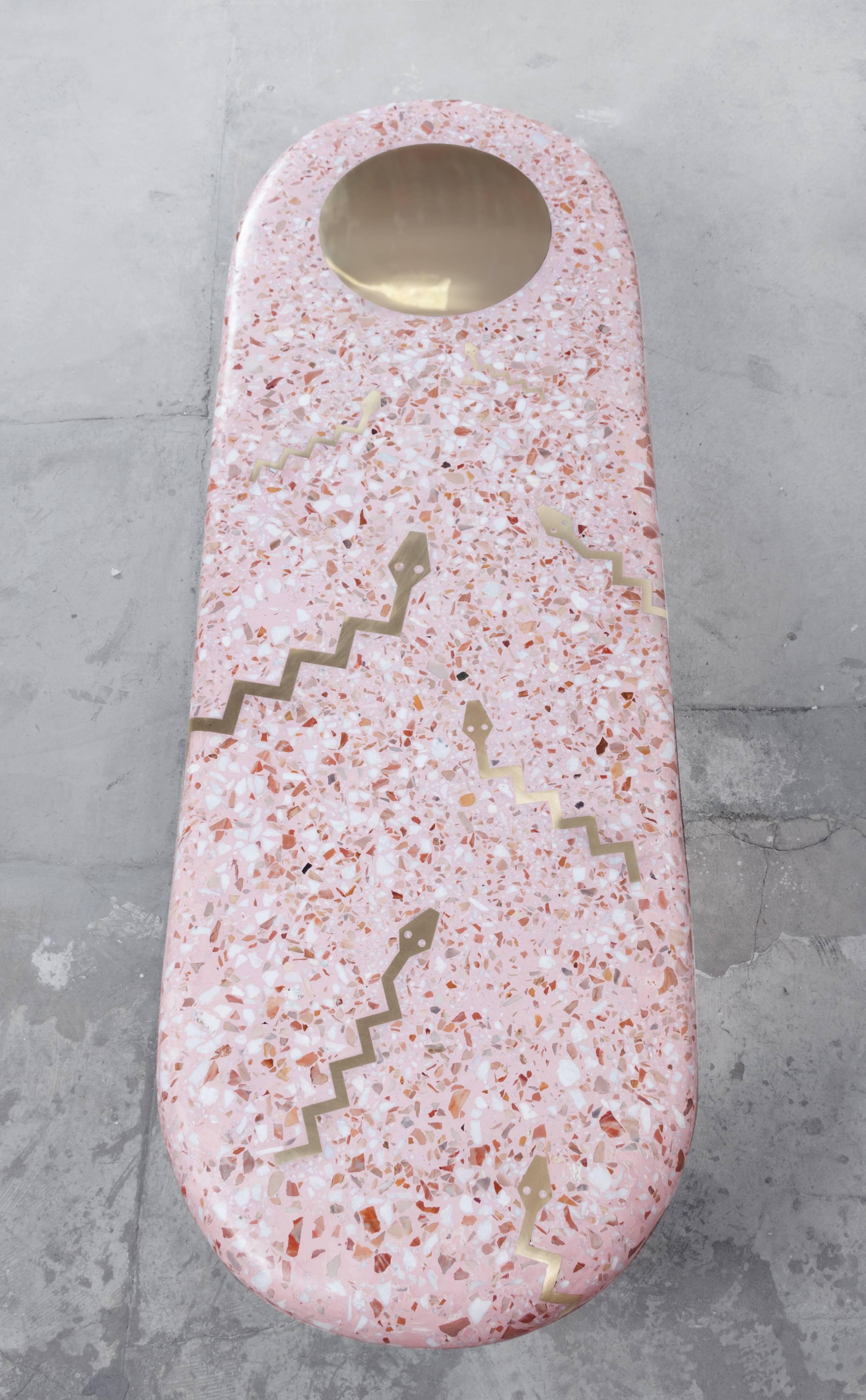 Run to the light sculptural terrazzo coffee table
Shown in pink cement, with natural white and brown marble with brass snake Inlays swimming toward a large brass sun and one cylindrical brass leg.

Custom color, shape, size, and inlays