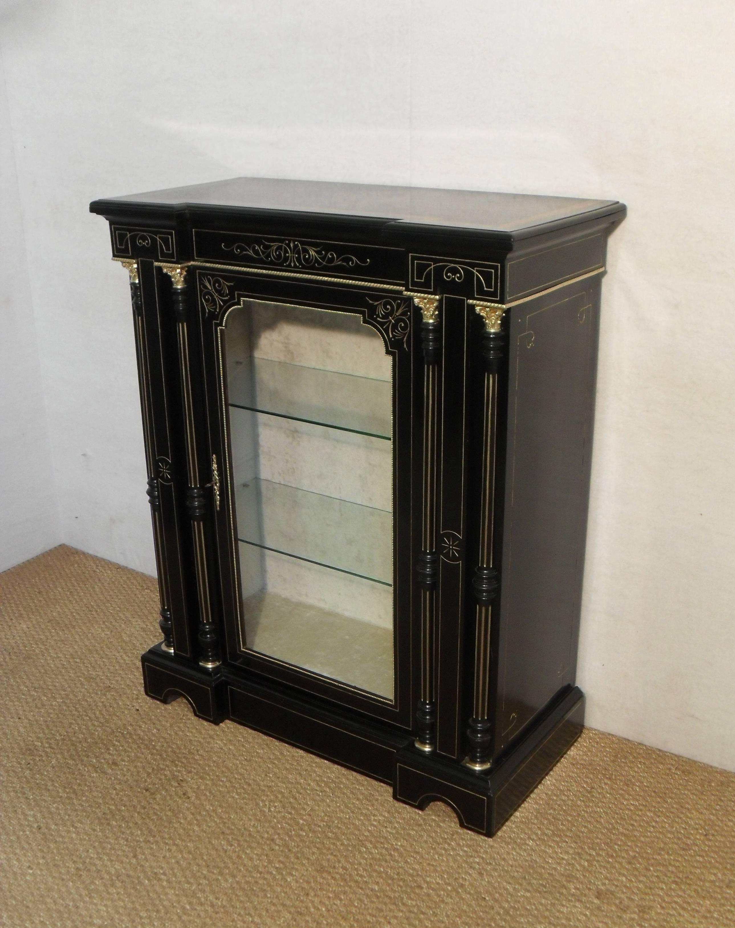 An exceptional quality and stylish pair of Victorian Aesthetic movement inverted break front ebonised pier display cabinets or bookcases. The cabinets have carved gilded decoration with two half turned fluted gilded columns to each side with bronze