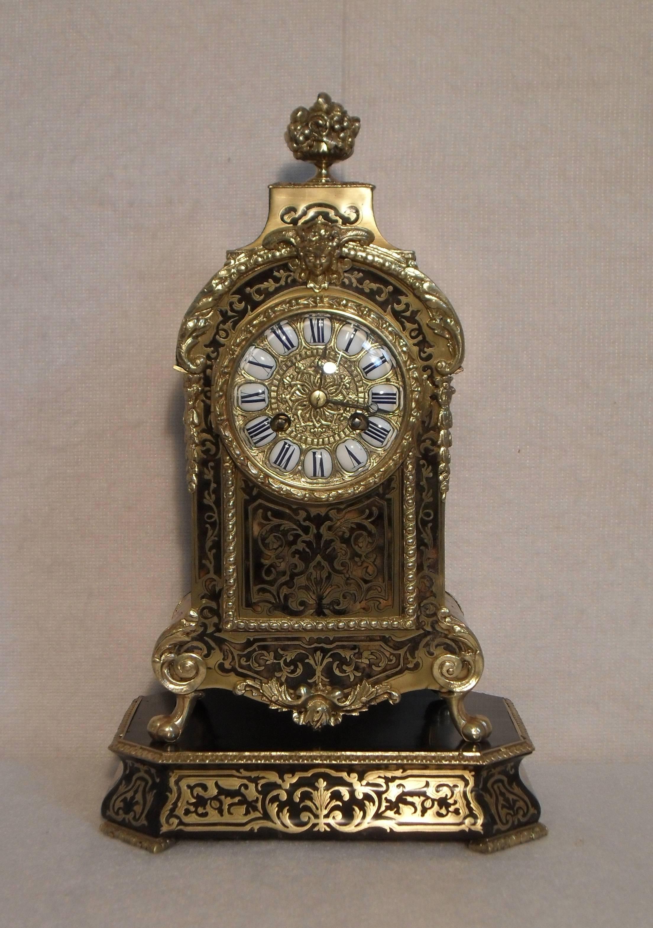 A very good quality French boulle natural coloured tortoise shell and brass inlaid mantel clock with ormolu mounts on shaped boulle base. The clock has a decorative gilt brass dial with white enamel numerals and a French eight day movement which