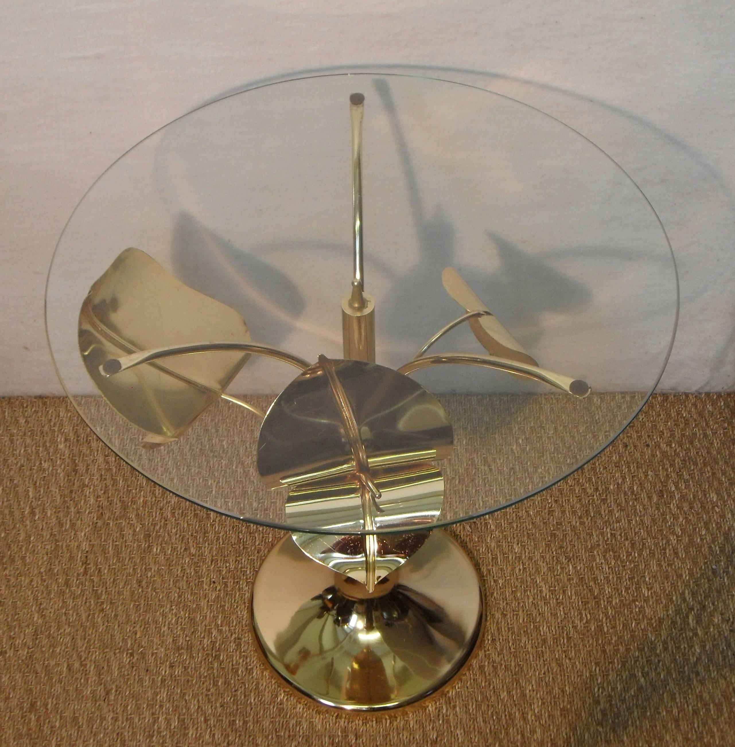 A stylish Italian Mid-Century gilt metal side table on trumpet shaped base with elegantly formed anthurium flowers and leaf. The table has its original clear glass circular top.