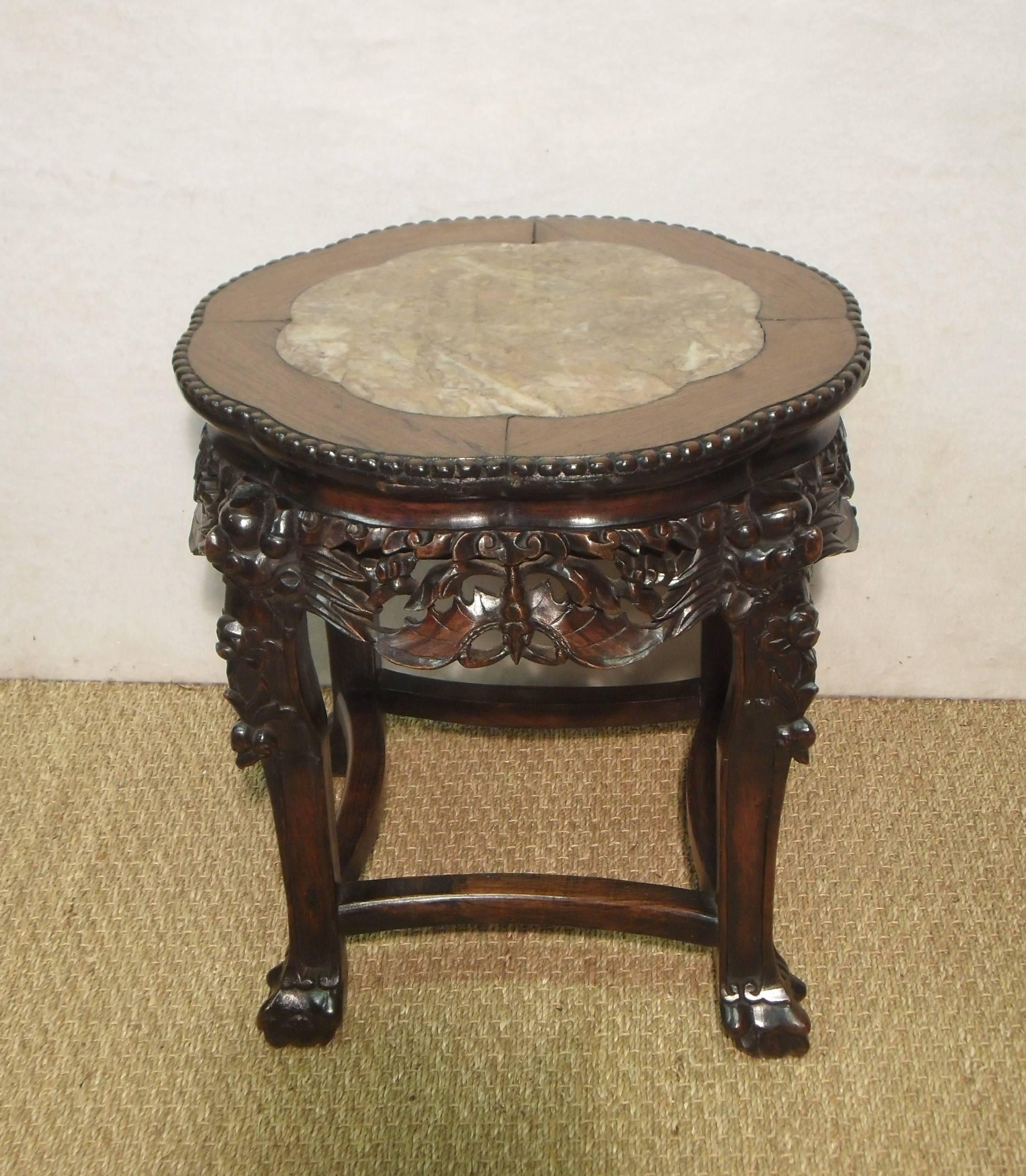 An extremely good quality Chinese rosewood stand or table carved with bats to the frieze and dragons to the legs finishing into a ball and claw foot. The Stand still retains its original inset marble top with carved beaded edge.