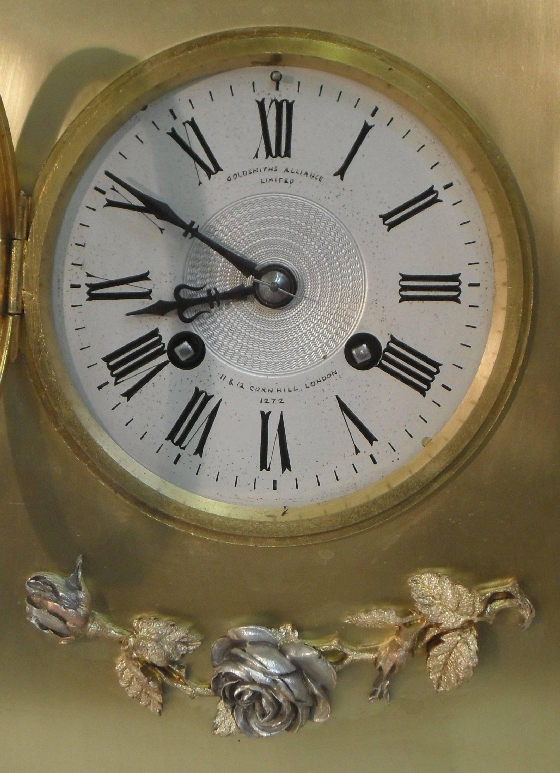 A very good quality brass and gilt mantel clock with gilt and silver side columns and finial. The clock has a silvered dial with an eight day French movement which strikes the hours and half hours on a gong. 
 
The clock has the retailer name on