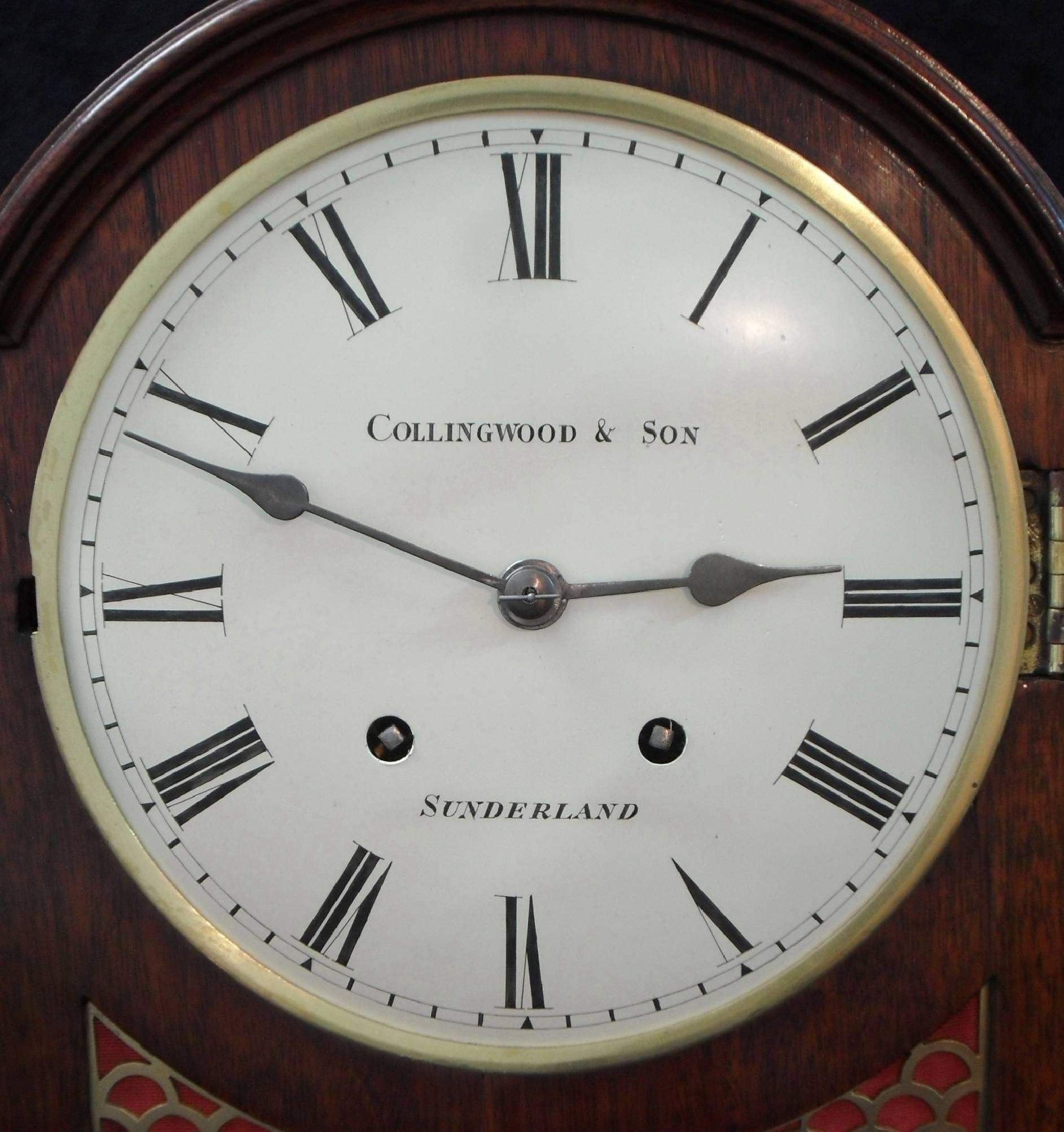 A very good quality mahogany bracket clock with fish scale sound frets to the front and side stood on brass ball feet with carrying handle.

The clock has a white enamel dial with the retailers name:-

Collingwood & Son
Sunderland

The