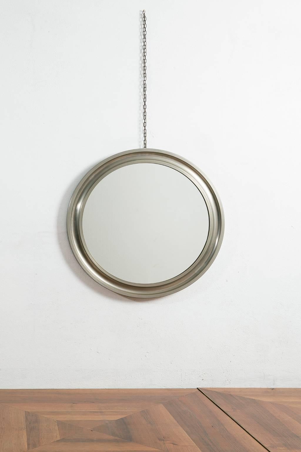 Nickel plated and satinized brass wall round mirror designed by Sergio Mazza for Artemide in 1969. Original patina.
The mirror is hanged by a chain set on metal frame's top side.

Italian designer Sergio Mazza is known for his plastic design and