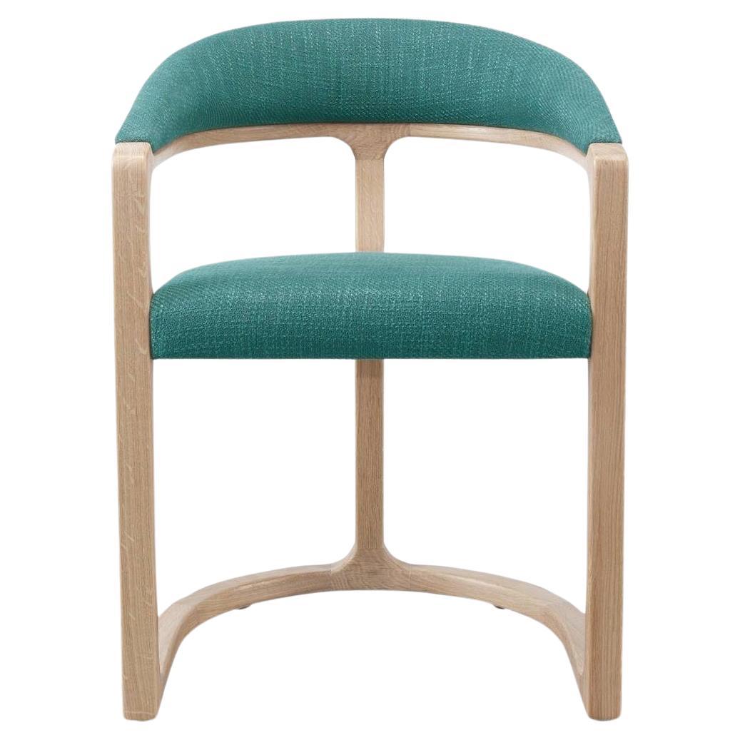 Dieser Stuhl verkörpert Schlichtheit und Verbundenheit. Er ist aus einem massiven Holzrahmen gefertigt, der wie aus einem Guss wirkt. Die Silhouette ist sorgfältig geformt, und die Tischlerarbeiten und die Polsterung zeugen von handwerklichem