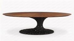 Mesa de comedor ovalada de estilo escultural con tablero de nogal y base de fundición con acabado lacado texturizado