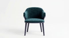 Sillón de comedor curvo y escultural, con estructura de roble y tapizado de tela