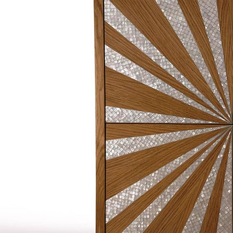 The Classic sun cabinet is crafted from French oakwood natural finish with a bold mother-of-pearl inlay. Legs are in brushed stainless steel. The four autonomously opening square doors allow for effortless access to storage contents without