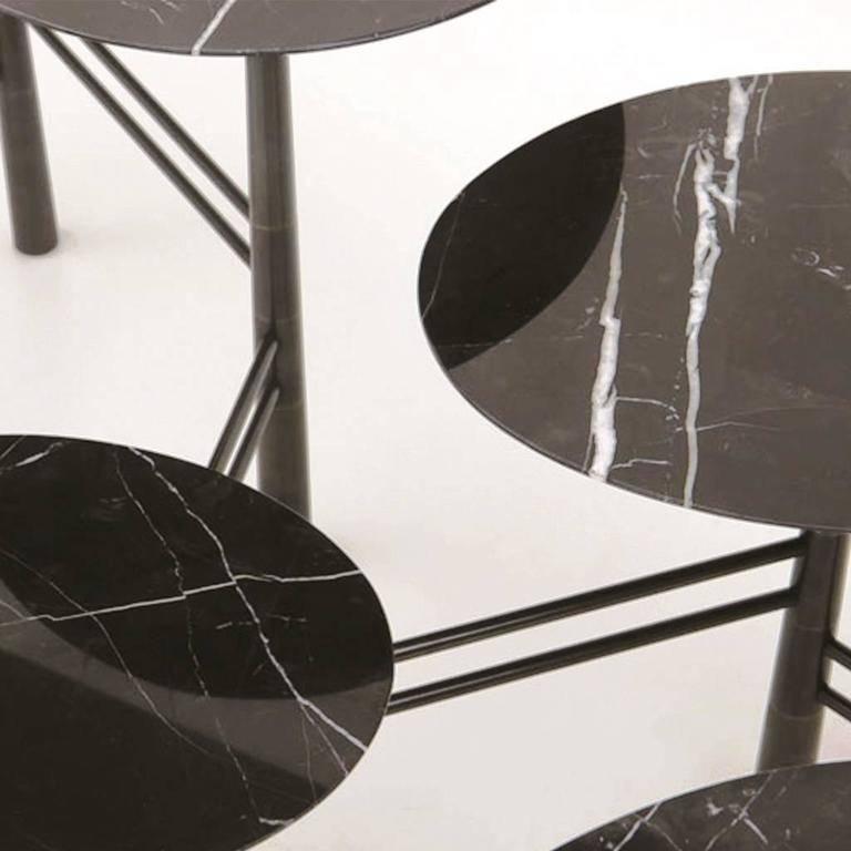 Inspired by pebbles on the beach, this contemporary coffee table is expandable and contractible with seven marble tops in Nero marquina and black lacquer steel base. The base is a masterpiece of sophisticated engineering. Solid steel uprights are