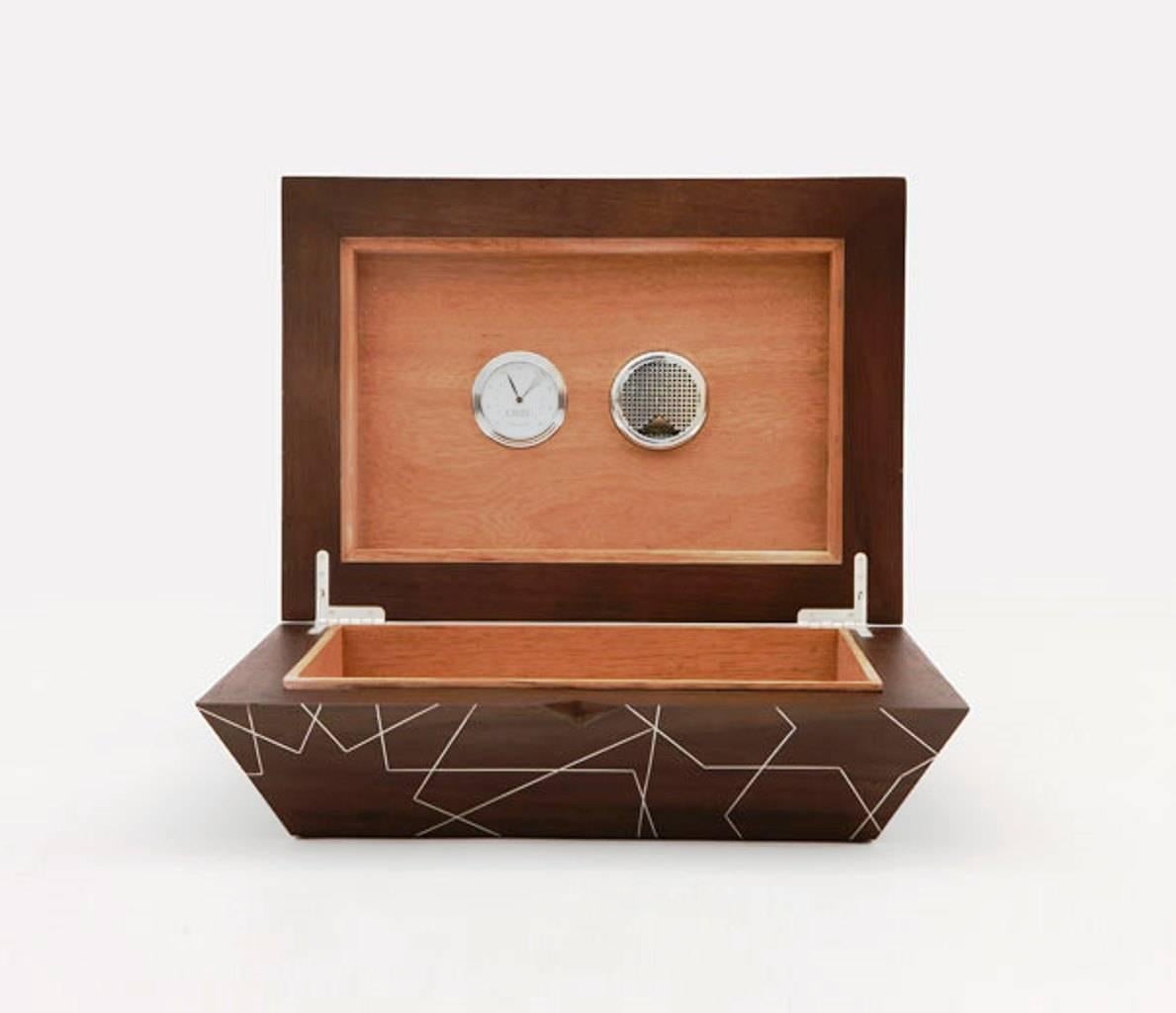 Designed around the classic lifestyle of the cigar smoker, the smoke cigar box by Nada Debs features a solid walnut wood structure with T1 tin inlay pattern, and a humidifier. The hand inlay designs are inspired by the traditional Middle Eastern