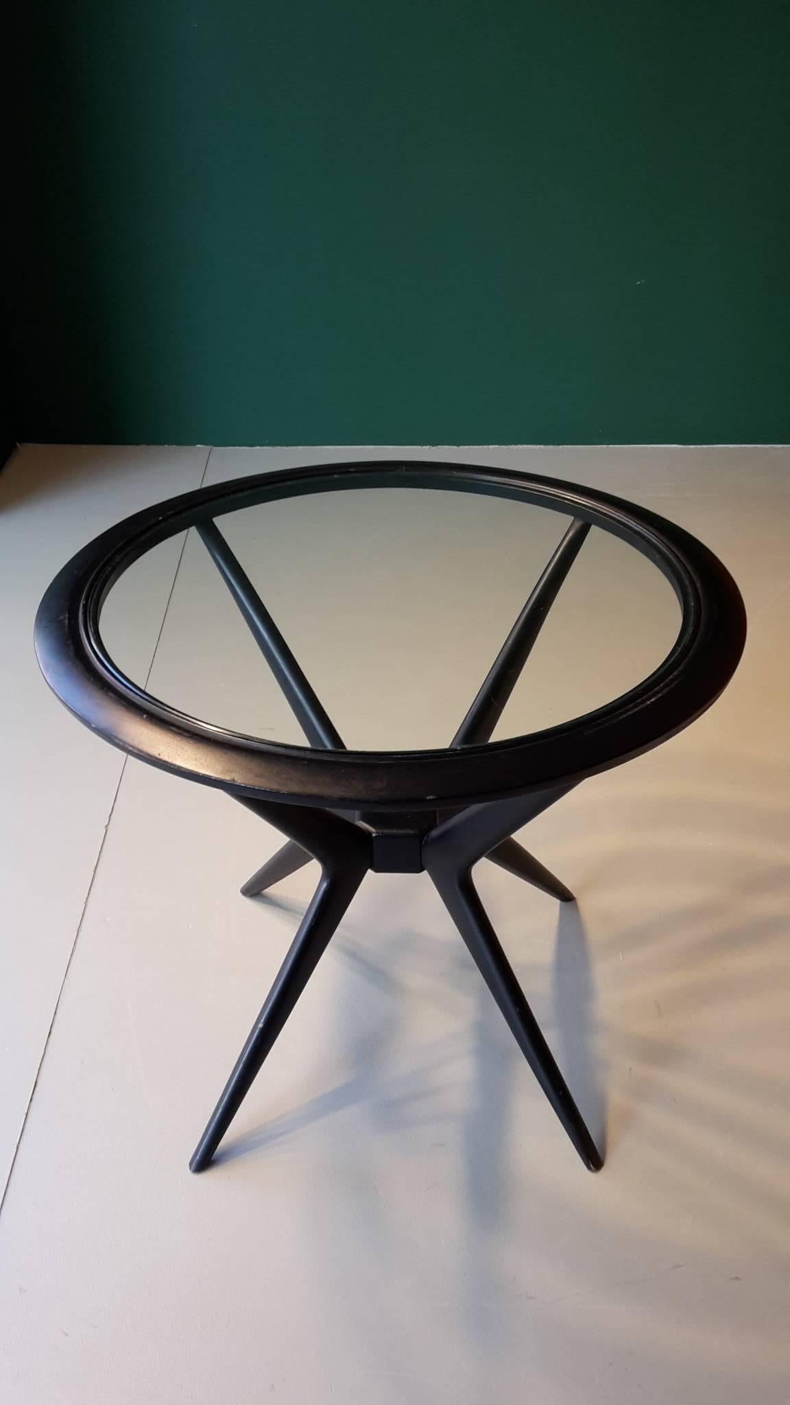 20th century Italian side table made of painted black wood and glass. The glass top is embedded in the round wooden frame.