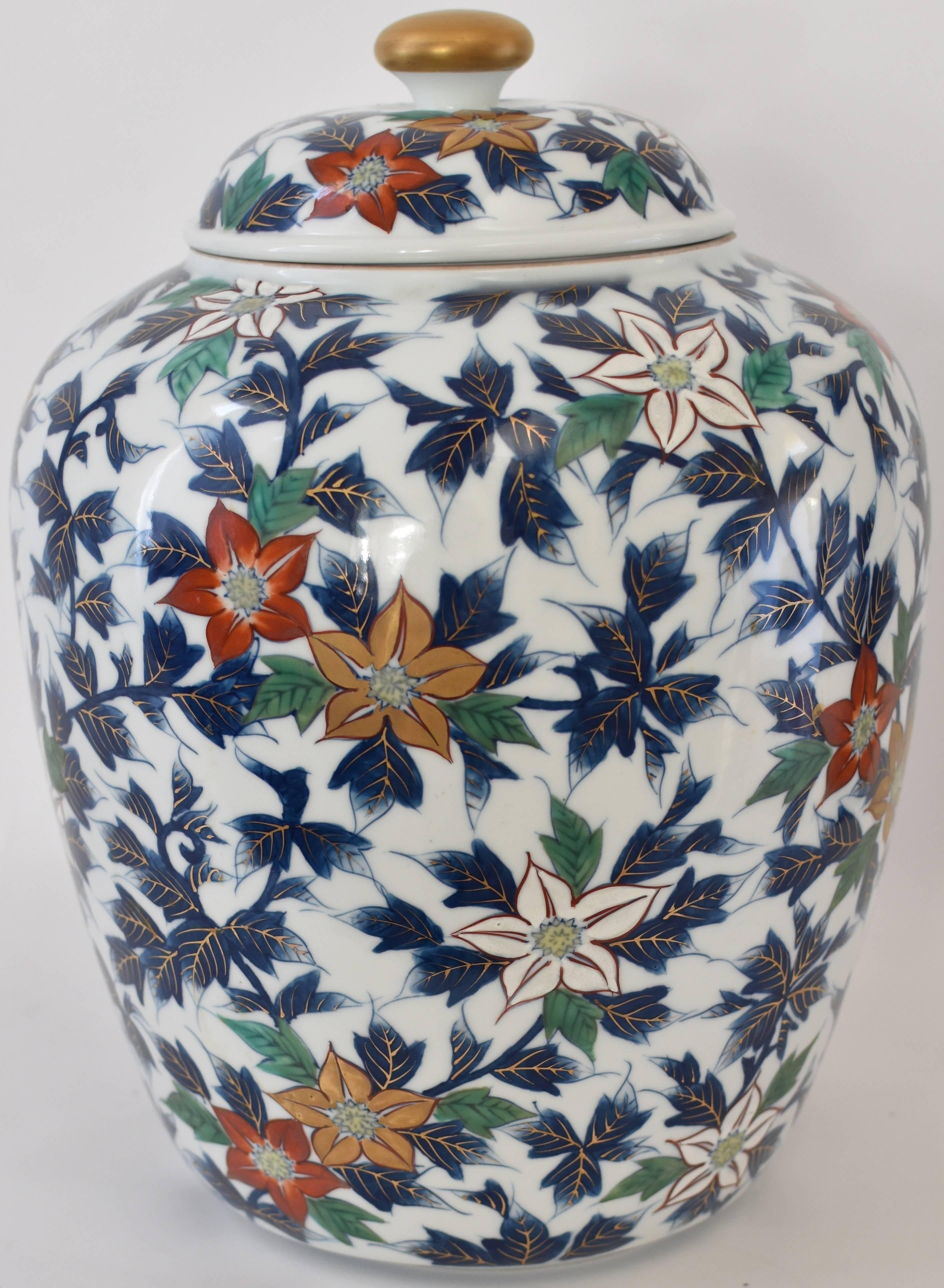 Japanese lidded porcelain temple jar, hand-painted in vivid blue, green, red and gold on an elegant ovoid shape body is a signed piece of the Shozan Kiln in the Imari-Arita region of southern Japan.
The vase depicts eye-catching flowers in rust-red,
