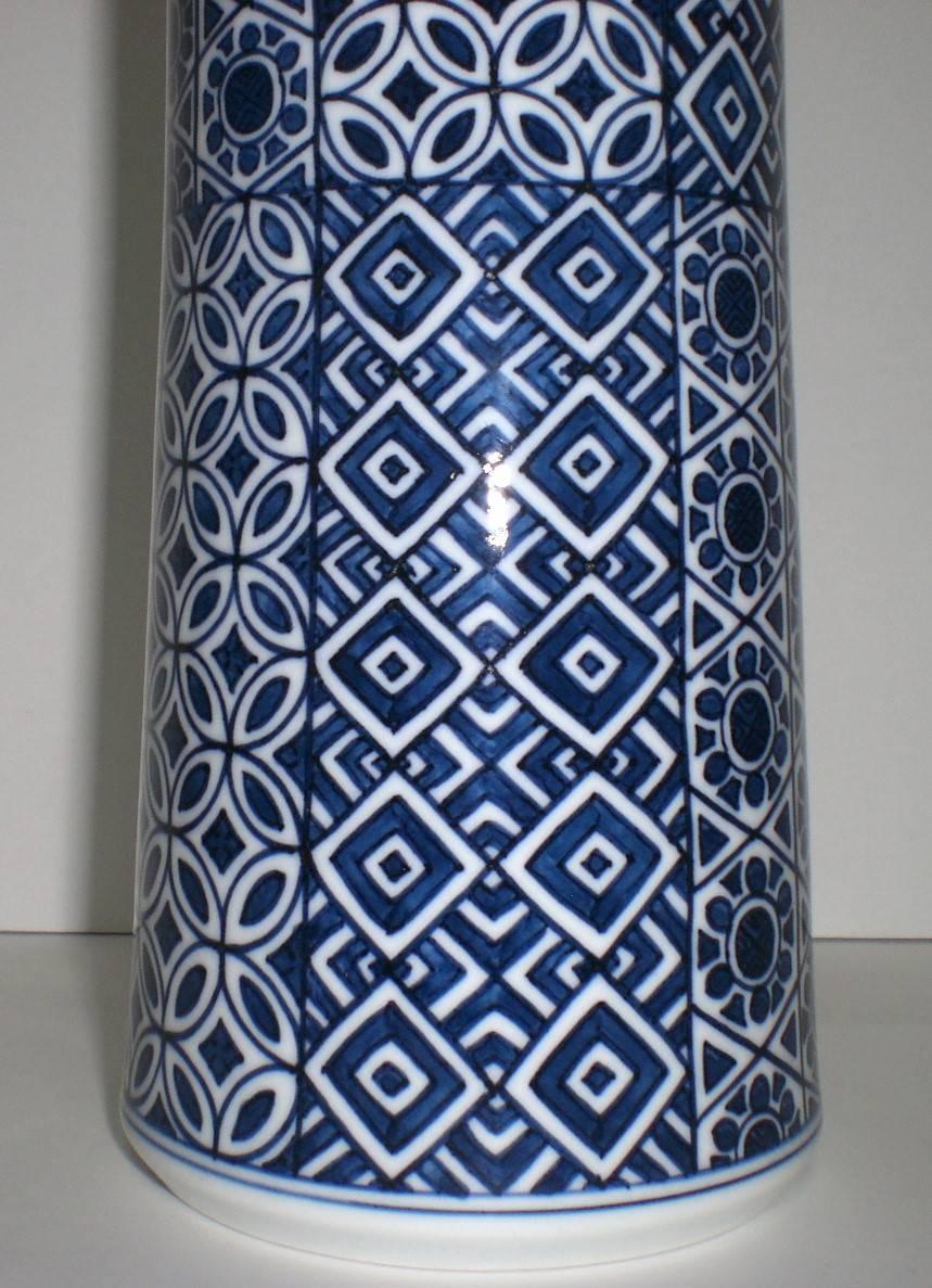 This Japanese decorative hand-painted porcelain vase in blue underglaze is a signed work by Genki Kunihiko, an award-winning master artist and the younger of a two-brother team of master porcelain artists working in the historic Imari-Arita region