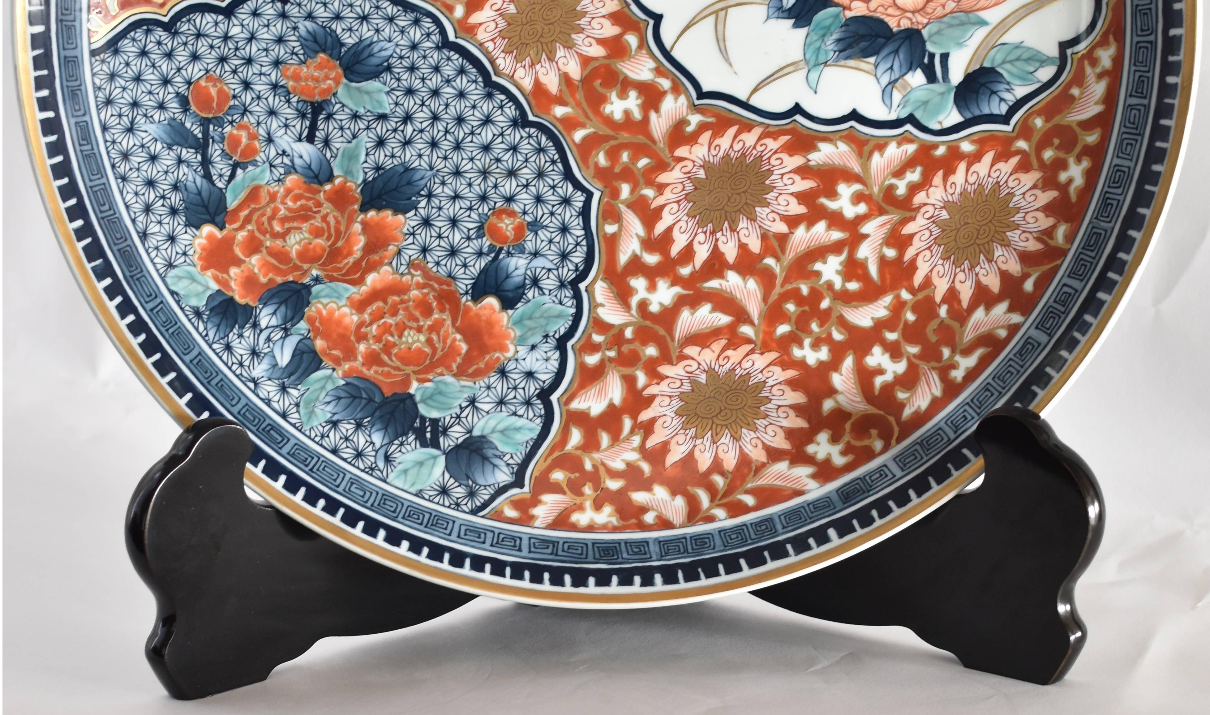 This large Japanese porcelain charger is crafted and hand-painted in the Imari-Arita region of southern Japan and is signed by Tadamine.

The asymmetric layout features two scalloped panels with peonies in full bloom. One panel depicts two peonies