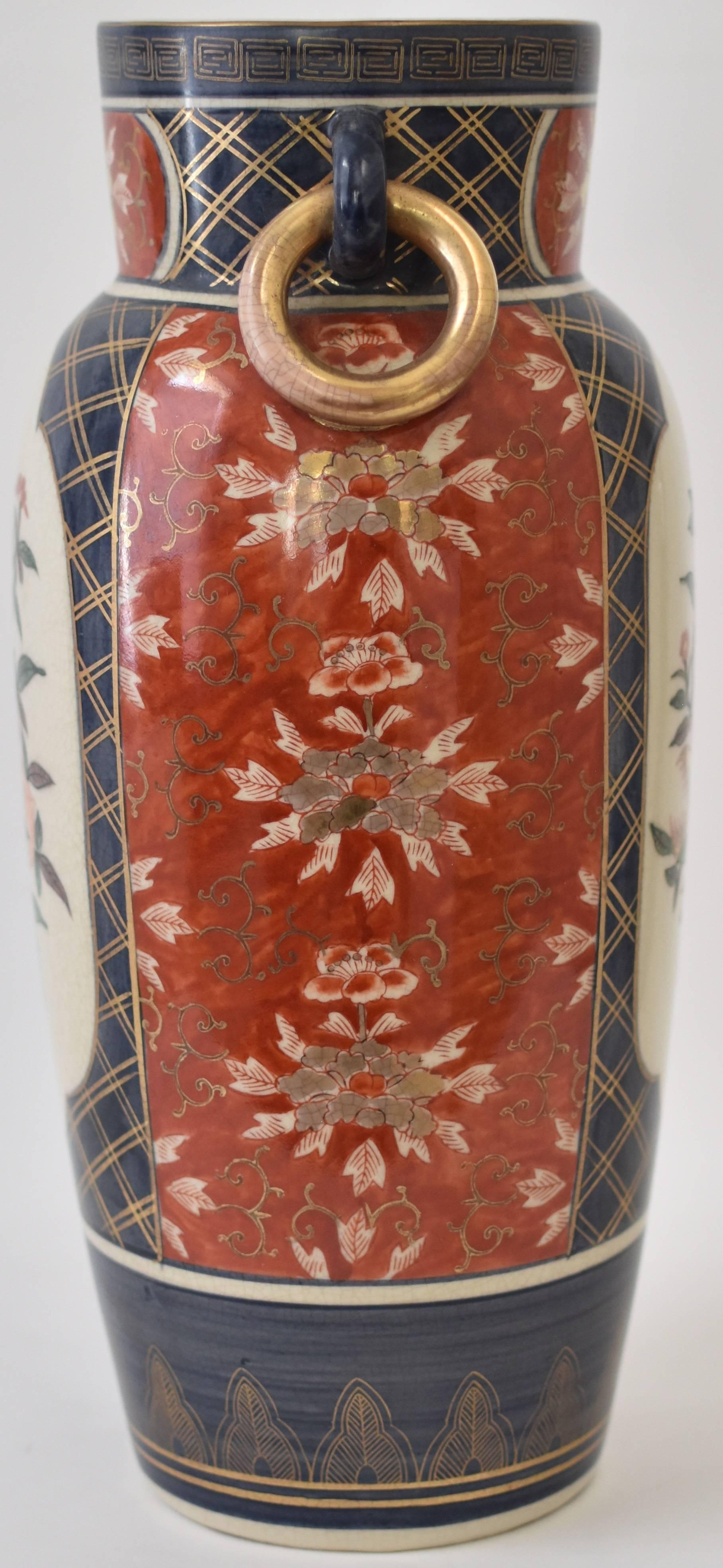 Die zeitgenössische japanische Porzellanvase mit vergoldeten Ringgriffen zeigt traditionelle Imari-Blumenmotive vor einem feinen Craquelé-Glasur-Hintergrund auf einem schön geformten Porzellankörper.

Auf den beiden mit Wellenschliff versehenen