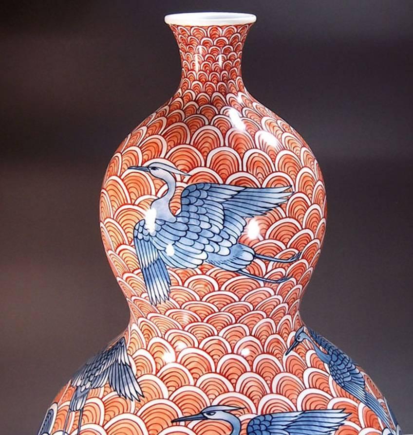 Japanische zeitgenössische dekorative Porzellanvase, aufwendig handbemalt in lebhaftem Rot und Blau auf einem atemberaubend geformten Porzellankörper mit doppelter Kalebasse. Ein signiertes Werk des hochgelobten Porzellankünstlers aus der