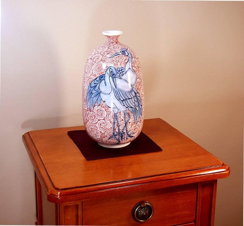 Vase décoratif unique en porcelaine japonaise contemporaine, peint à la main en bleu sous glaçure et en rouge sur un corps de porcelaine magnifiquement façonné en blanc pur. Il s'agit d'une pièce signée par le célèbre maître artiste de la porcelaine