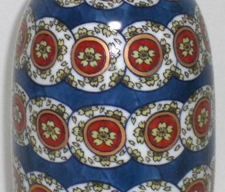 Exceptional decorative large porcelain vase, stunningly hand-painted in blue, red and white on a unique bottle shaped body, a signed masterpiece by master porcelain artist of the Imari-Arita region of Japan. This artist was the recipient of numerous