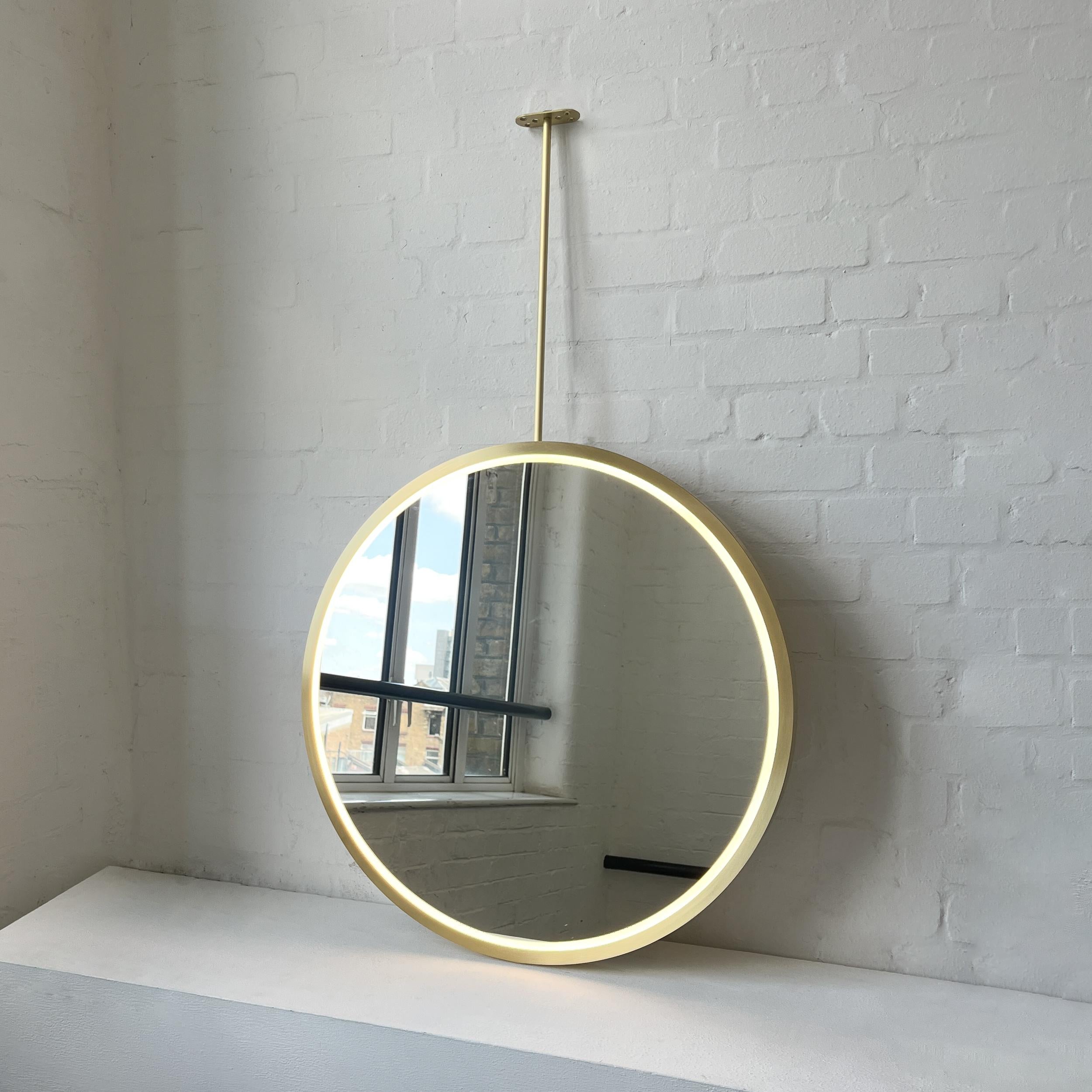 Contemporary front illuminated ceiling suspended Orbis™ round mirror with a modern brushed brass full frame. Designed and handcrafted in London, UK. This mirror is fully customisable to suit the specific requirements of each interior.

Dimensions: