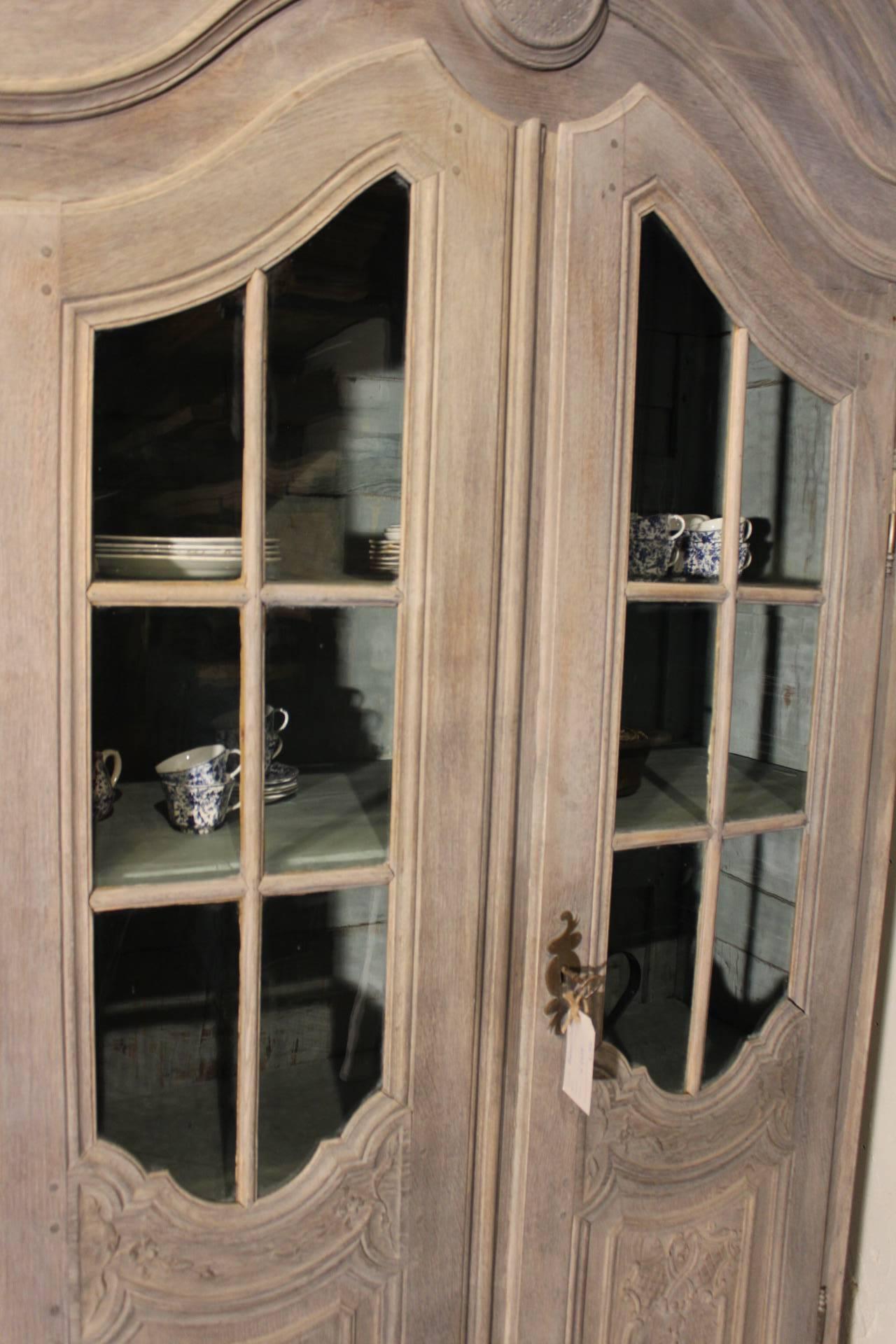 Oak made two-door glass cabinet complete original piece
the glas is still original even the key and keyplate
With a grey patina and a Old Blue painted inside
Fine carved details on panels and corners. 
Beautifull bild out crown.
Made in the Flemisch