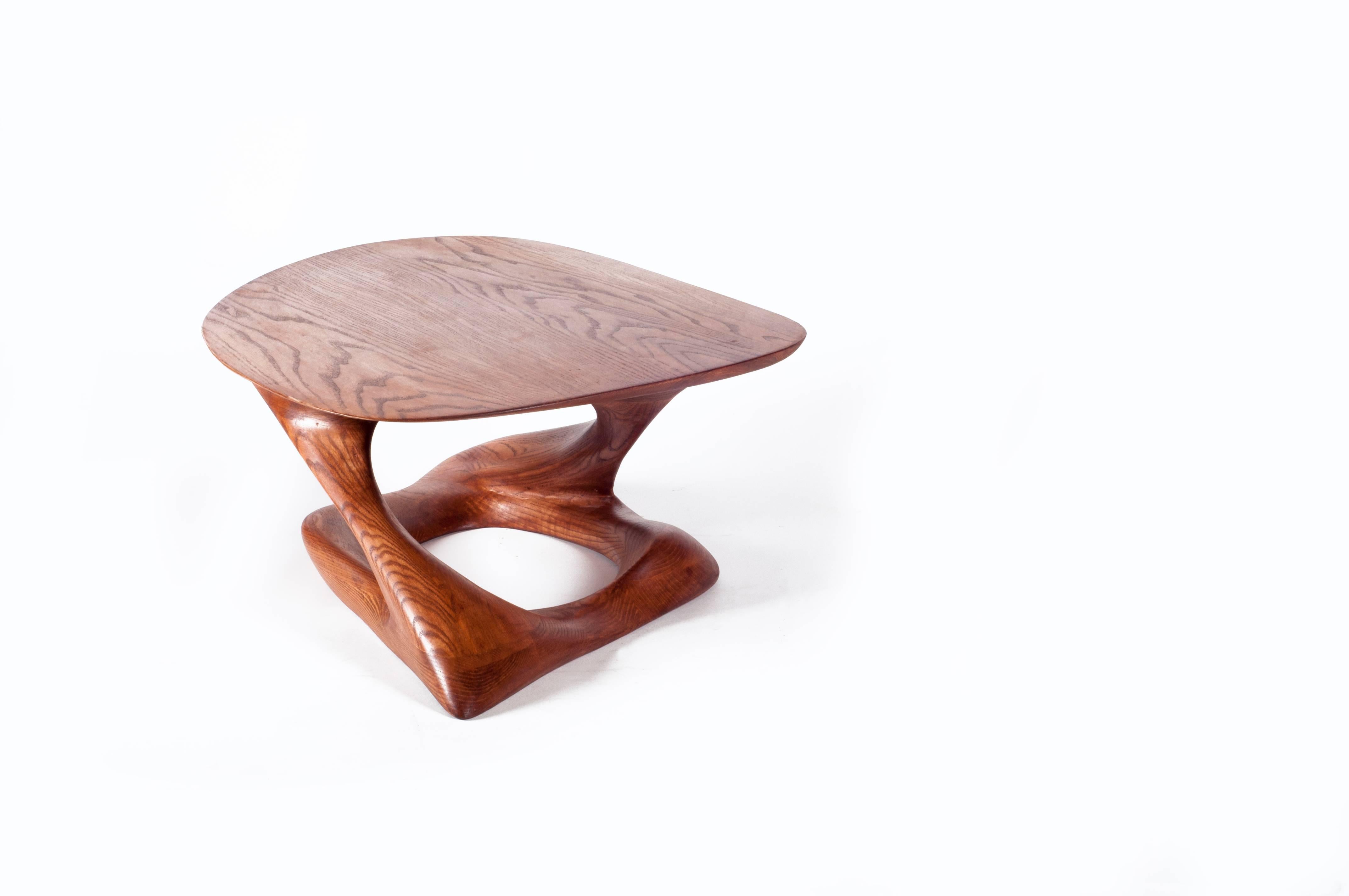 La table basse Plie est une table d'art sculpturale futuriste élégante avec une forme dynamique conçue et fabriquée par Amorph. Plie est fabriqué en frêne massif et teinté en noyer foncé. Par nature, l'aspect du grain de bois de frêne sera