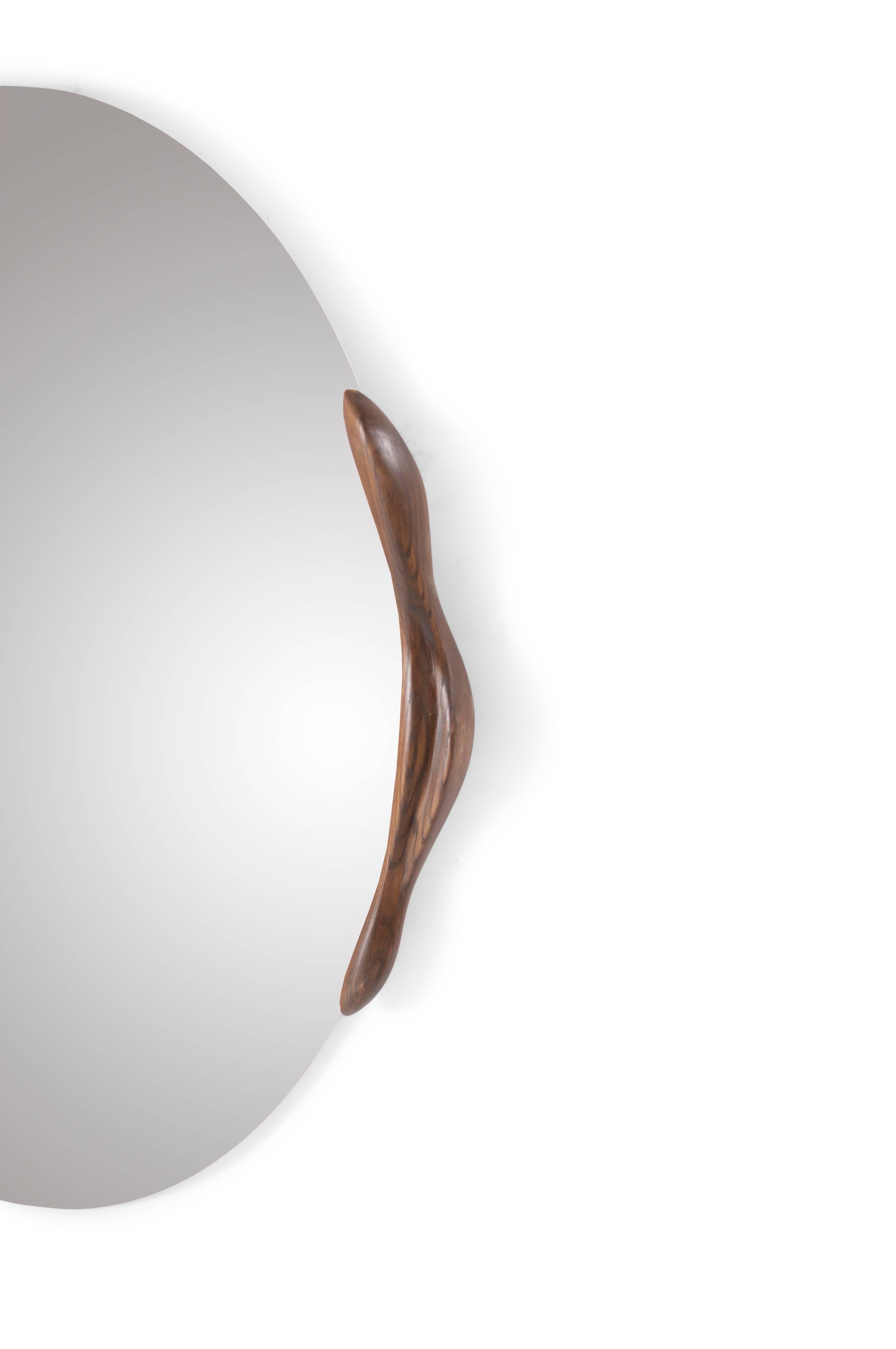 Miroir de forme ovale en frêne teinté noyer rouillé, conçu et fabriqué par Amorph.
Epaisseur du miroir 1/4