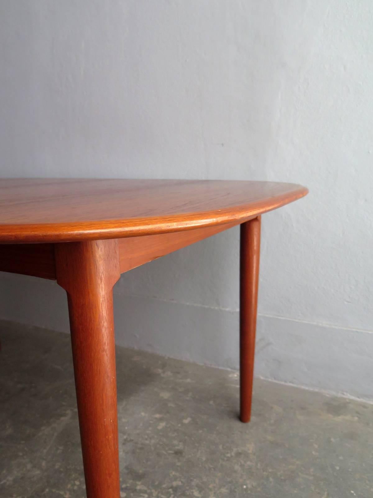 Danish teak elegant dining table with two extensions leafs. Rounded corners and edges. Beautiful teak grain. Carefully restored.