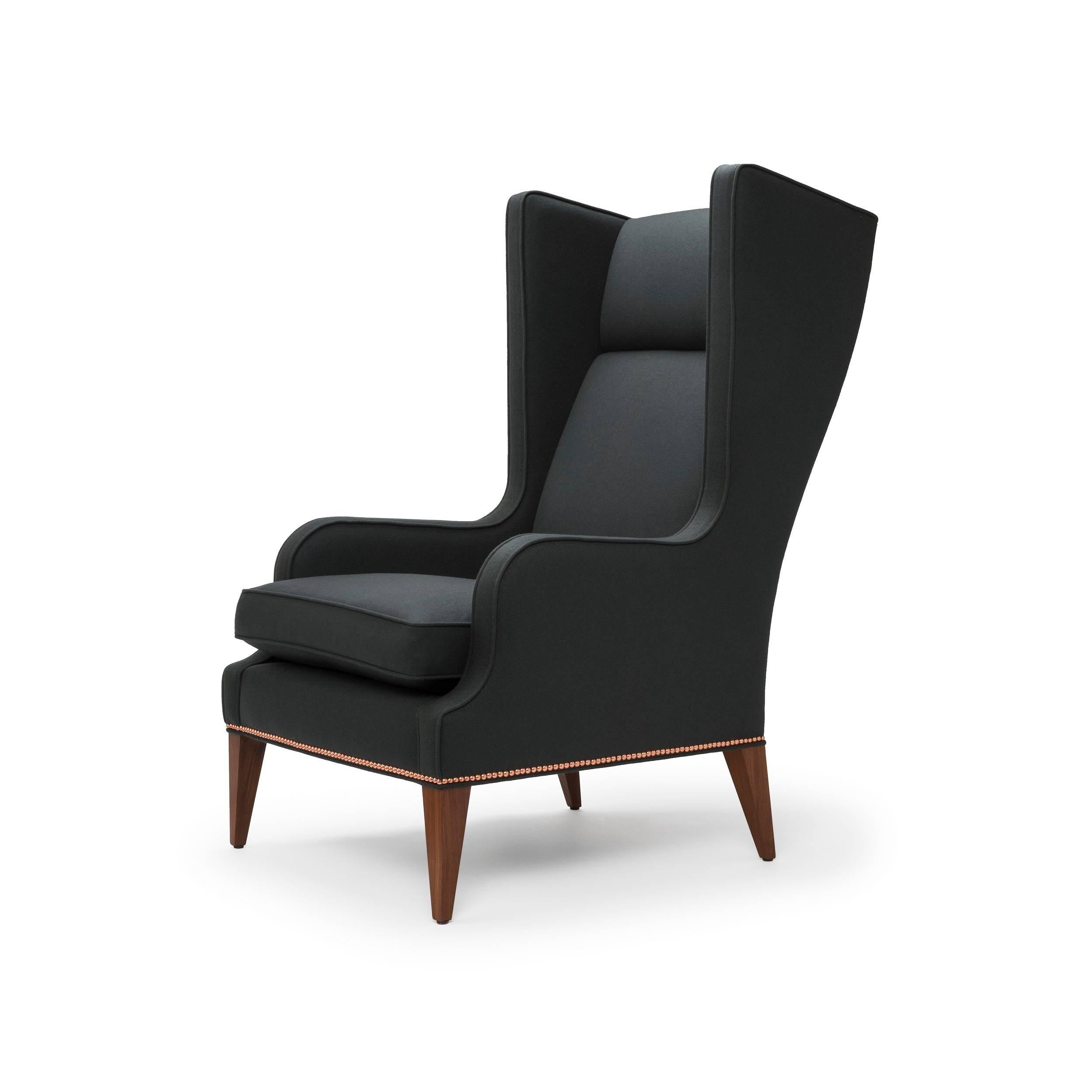 The Alae is available as a Wing or Lounge Chair and features sleek sculptural lines. The seat is softened perfectly with a luxurious feather and down wrapped cushion. The Alae Wing Chair shown here upholstered in Charcoal Melton Wool with legs in
