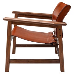 Poltrona contemporanea Saddle Up in pelle Tan Hide Saddle e noce naturale