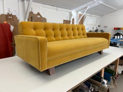 Divano Adoni di Stuart Scott in velluto di mohair Grand color ottone con gambe in noce